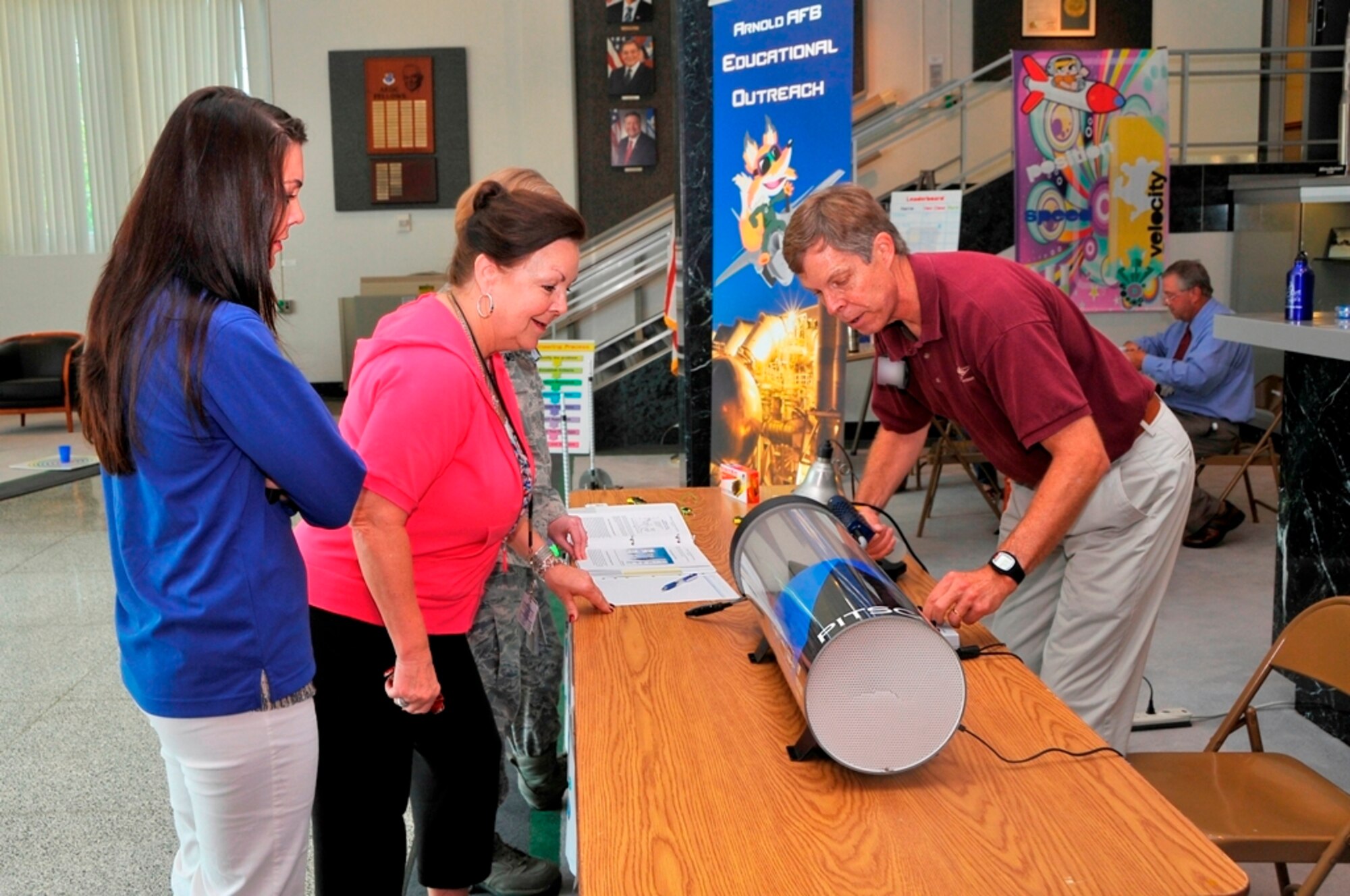 Dow Jones, AEDC contracting officer, and her daughter, Holly Jones, with base services, watch as Jere Matty, AEDC’s STEM educational outreach specialist, sets up a flow visualization tunnel at a presentation of STEM teaching aids held recently in the lobby of the A&E Building. The tunnel was one of a number of teaching aids on display to promote educations and careers in science, technology, engineering and mathematics fields to kindergarten through senior high school students in the surrounding counties. (Photo by Jacqueline Cowan)