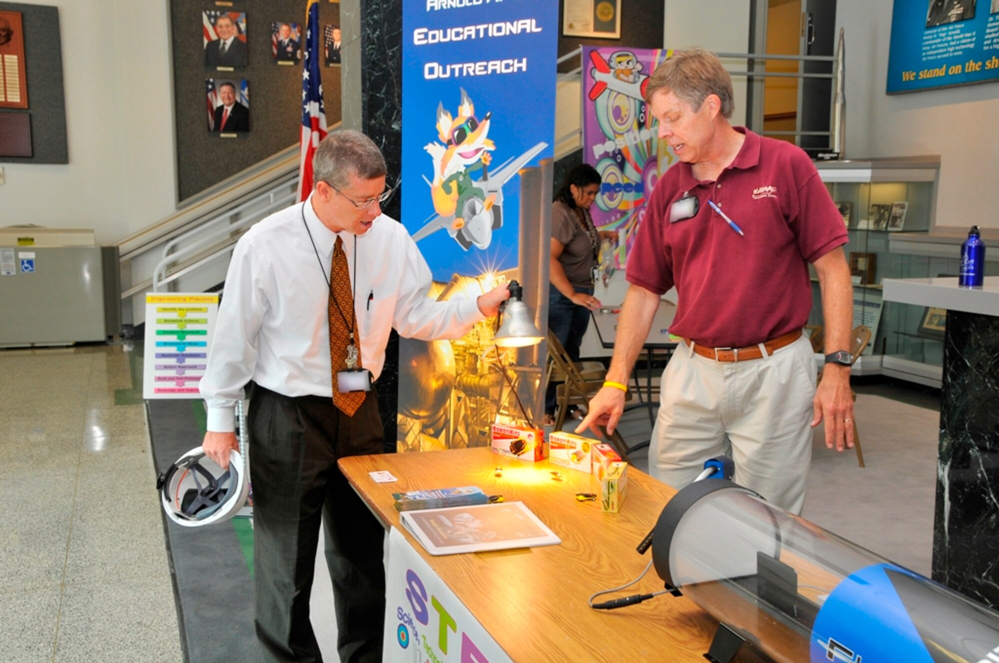 Britt Covington, AEDC’s executive director, examines some solar-themed teaching aids as Jere Matty, AEDC’s STEM educational outreach specialist, talks about how the STEM demonstration aids can be used to provide local students with a visual, hands-on idea of how science, technology, engineering and mathematics principles are applied. (Photo by Jacqueline Cowan)