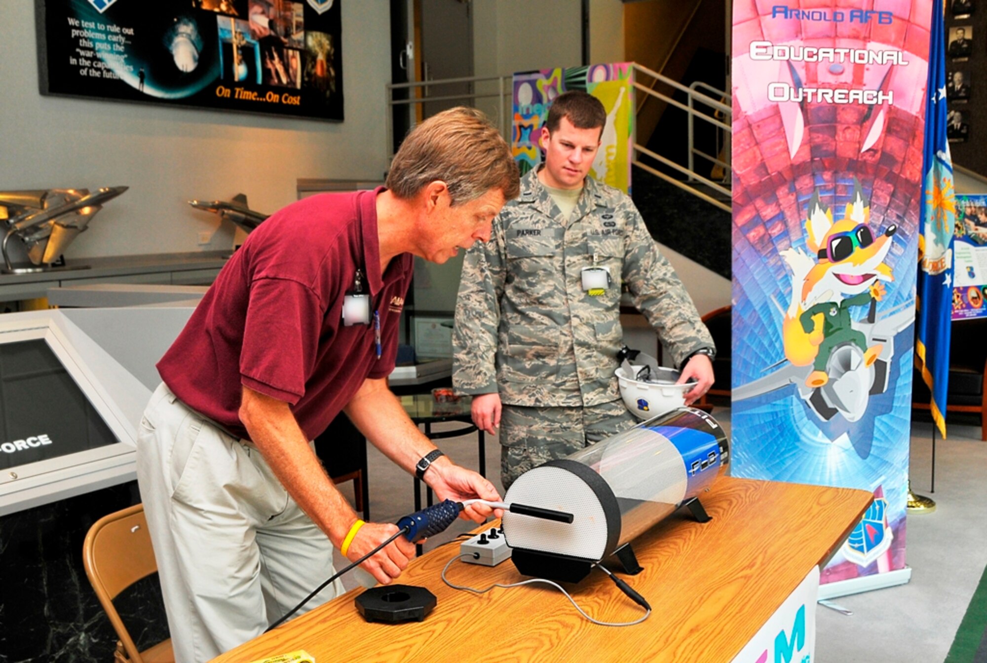 Jere Matty, AEDC’s STEM educational outreach specialist, shows 1st Lt. Will Parker, AEDC’s commander’s executive officer, how to operate the flow visualization tunnel at a presentation of STEM teaching aids held recently in the lobby of the A&E Building. Matty, AEDC’s Air Force officers and engineers visit local public schools to hold STEM events to encourage young people to pursue science, technology, engineering and mathematics educations and careers. (Photo by Jacqueline Cowan)