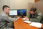 Airman 1st Class Kevin Failla (left), 902nd Comptroller Squadron finance technician, helps Capt. Danny Elich, 359th Aerospace Medical Squadron physiology branch, fill out a travel voucher on Joint Base San Antonio-Randolph, Texas, July 10. (U.S. Air Force photo by Rich McFadden) 