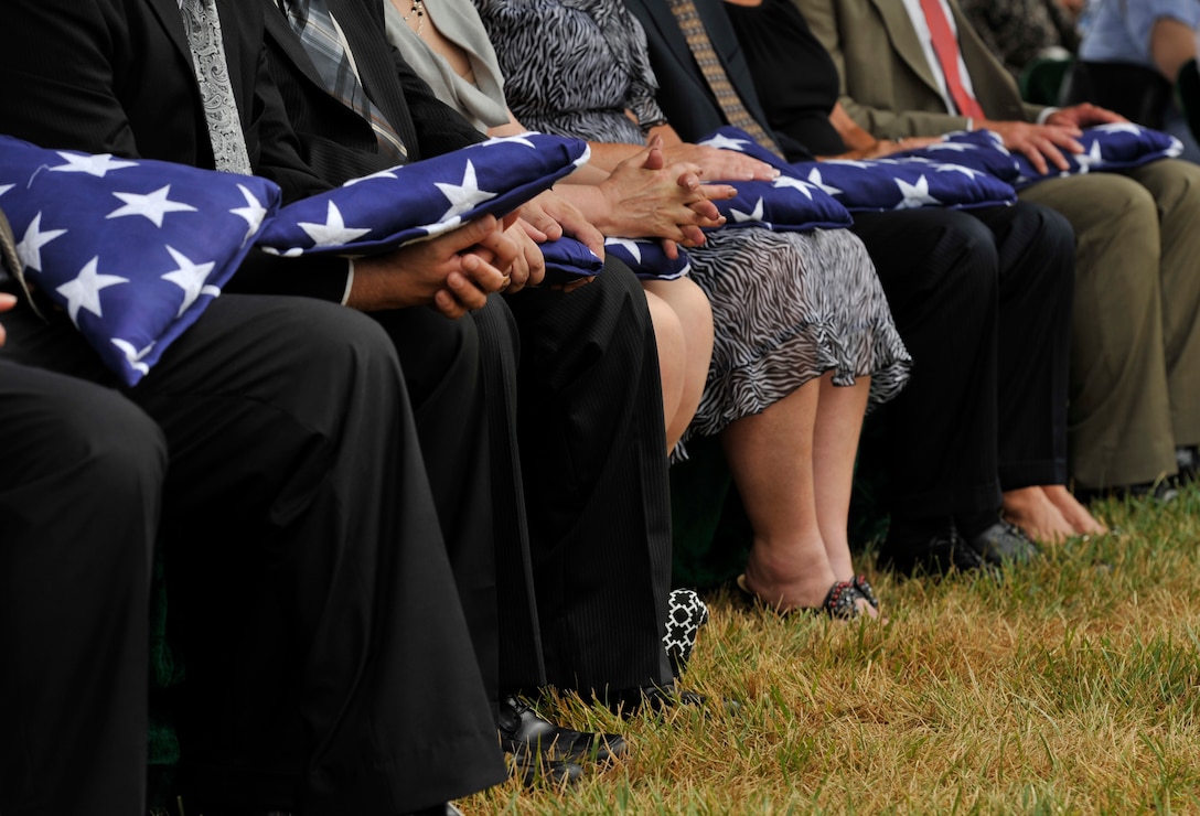 Family members hold onto their folded flags July 9 at Arlington National Cemetery in Arlington, Va. The funeral laid to rest the remains of six Airmen who went missing when their Douglas AC-47 Spooky gunship crashed in Laos on Christmas Eve 1965 during a Vietnam combat mission. These Airmen were buried in Arlington after being identified through dental records, personal items and other circumstantial evidence. (U.S. Air Force photo/Senior Airman Perry Aston)