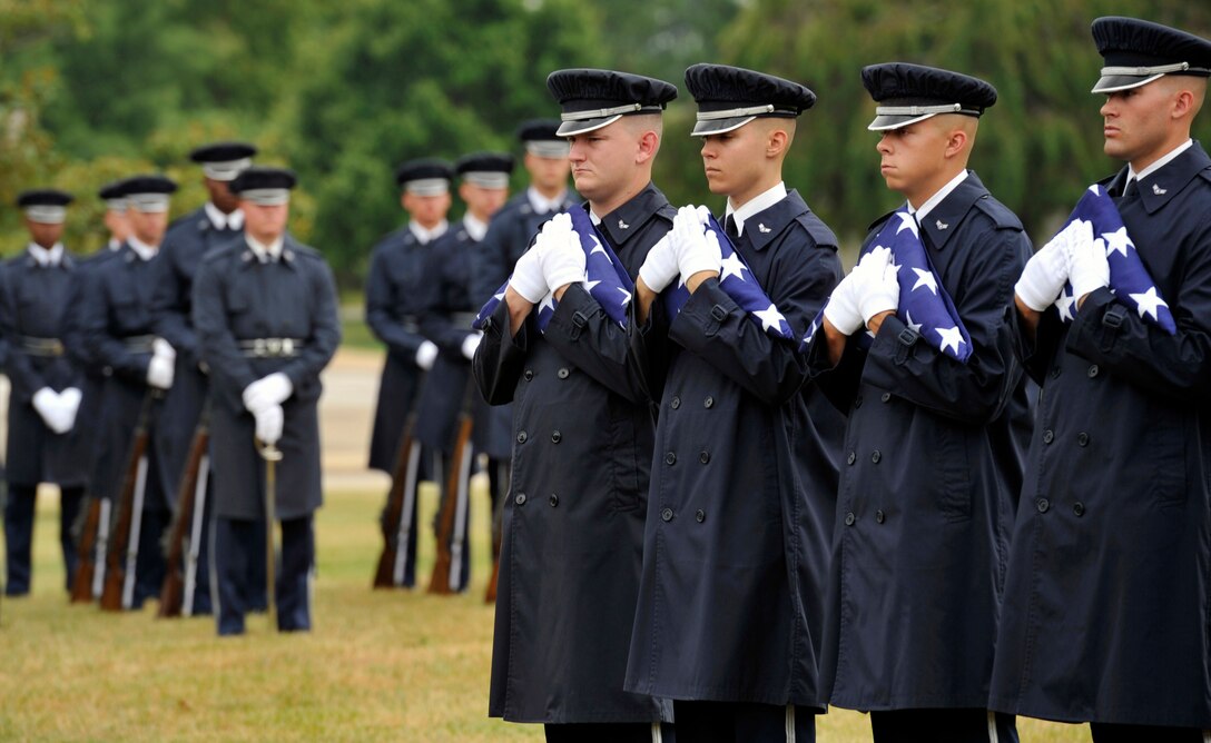 U.S. Air Force Honor Guard ceremonial gaurdsmen hold folded flags during a funeral ceremony July 9 at Arlington National Cemetery in Arlington, Va. The ceremony laid to rest the remains of the six Airmen who went missing when their Douglas AC-47 Spooky gunship crashed in Laos on Christmas Eve 1965 during a Vietnam combat mission. The Airmen were buried in Arlington after being identified through dental records, personal items and other circumstantial evidence. (U.S. Air Force photo/ Senior Airman Perry Aston)