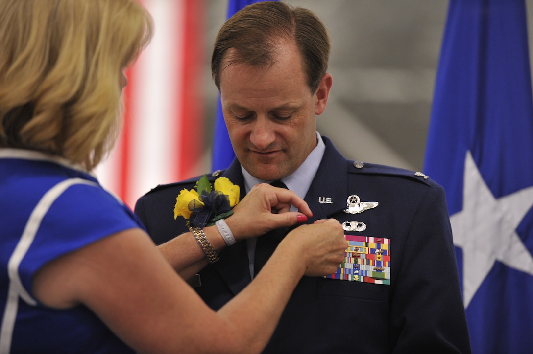 Cheri Rizer, wife of Col. Ken Rizer, pins the retirement pin on Col. Ken Rizer, former 11th Wing/Joint Base Andrews commander, on July 6. Rizer reliqueshed command of 11th Wing during the ceremony and retired after more than 25 years of service. (U.S. Air Force photo/Senior Airman Perry Aston)