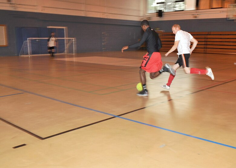 RAF MILDENHALL, England – Esean Rose, 100th Security Forces Squadron, defends the ball from Martin Parker, 100th Civil Engineer Squadron, during an Intramural Indoor Soccer match at the North Side Fitness Center July 10, 2012. The CES took the win with a final score of 8-4. (U.S. Air Force photo/Senior Airman Jerilyn Quintanilla)