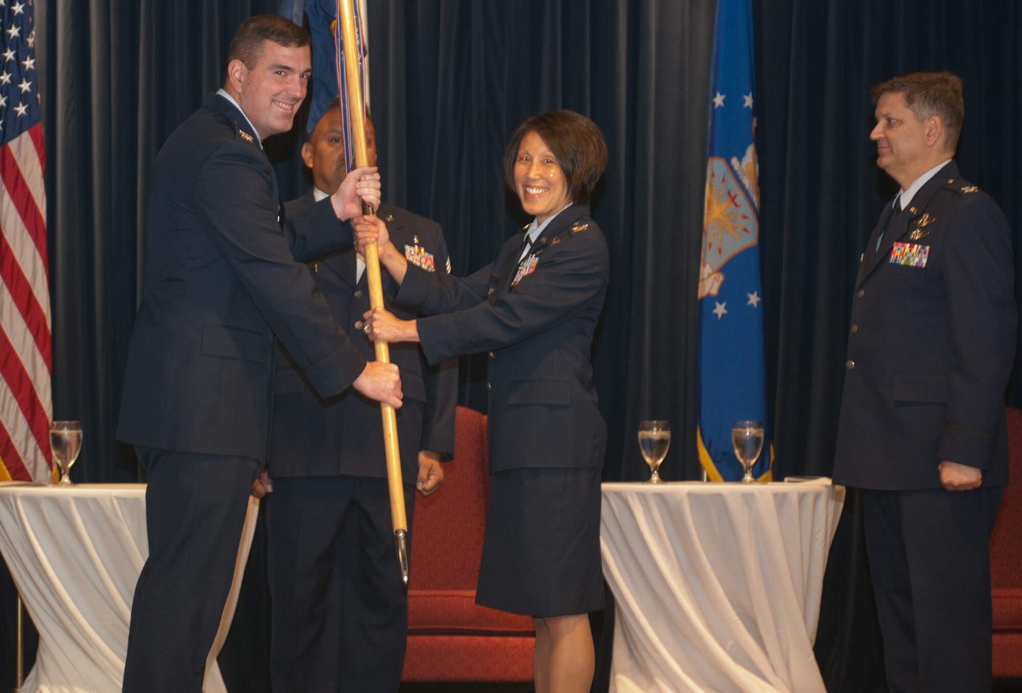 YOKOTA AIR BASE, Japan -- Col. Mark August, 374th Airlift Wing commander, left, hands the 374th Medical Group guidon to Col. Eveline Yao, the new 374 MDG commander, during a change of command ceremony at Yokota Air Base, Japan, July 9, 2012. The passing of the guidon to the new commander signifies the start of the new command. (U.S. Air Force photo by Airman 1st Class John D. Partlow)
