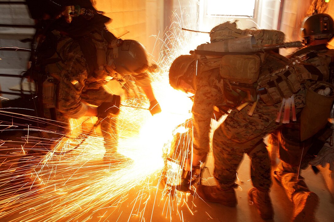 U.S. Marines use a circular saw to ignite a Brocos torch while attempting to breach steel barricades during a training exercise on Camp Fuji, Shizouka, Japan, July 9, 2012. The Marines are assigned to 31st Marine Expeditionary Unit's Maritime Raid Force. 