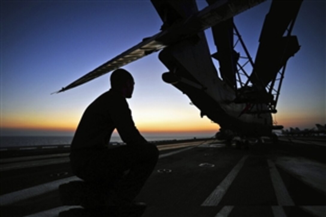 U.S. Navy Airman William Kegley watches the sunrise on the flight deck of the aircraft carrier USS Dwight D. Eisenhower under way in the Mediterranean Sea, July 10, 2012. Kegley is assigned to Strike Fighter Squadron 83. The Dwight D. Eisenhower is conducting maritime security operations and theater security cooperation efforts in the U.S. 6th Fleet area of responsibility. 