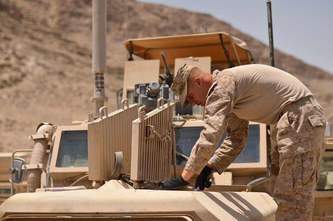 Cpl. Adam R. Tornatore, wrecker operator, Support Company, Combat Logistics Battalion 4, 1st Marine Logistics Group (Forward), examines the engine of a Mine Resistant Ambush Protected Vehicle at Forward Operating Base Zebrugge, July 11. The MRAP suffered engine problems during the patrol, and needed to be recovered on site by Tornatore and the Marines of CLB-4.