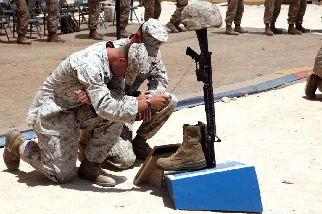 Marines with Delta Company, 1st Battalion, 7th Marines, Regimental Combat Team 6, pay their respects to a fallen comrade during a memorial ceremony, July 8, 2012. During the ceremony, Marines paid tribute to Pfc. Steven P. Stevens II, Lance Cpl. Niall W. Coti-Sears, Lance Cpl. Hunter D. Hogan and Lance Cpl. Eugene C. Mills III. Stevens and Mills were killed in action June 22 while participating in Operation Jaws in the Sangin Valley District, Afghanistan. Hogan and Coti-Sears were killed in action the following day during the same operation. Stevens was a combat engineer with 1st Combat Engineer Battalion supporting Weapons Company. Coti-Sears was a rifleman with Weapons Co. Hogan and Mills were riflemen with Bravo Co. attached to Weapons Co.