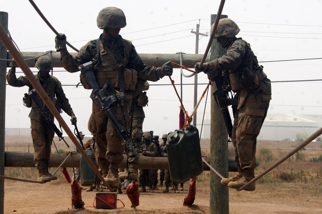 Recruits of Company G, 2nd Recruit Training Battalion, work together to carry an ammunition can across a simulated broken bridge during the Crucible at Edson Range aboard Marine Corps Base Camp Pendleton, Calif July 10. The Crucible is a 54-hour field-training exercise that puts recruits to the test by forcing them to use skills and principles they have learned throughout recruit training in order to complete simulated missions. Each event requires recruits to work together as a team to be successful.