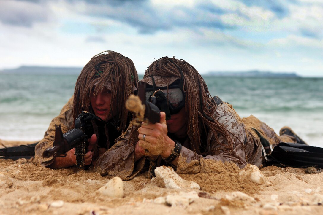 Marines secure the beach after conducting a clandestine landing at the Kin Blue Training Area during a scout swimmers course April 30. The Marines landed in pairs to provide security for each other as they moved up the beach. Course attendees included Marines with 3rd Intelligence Battalion and 3rd Radio Battalion, both part of III Marine Expeditionary Force Headquarters Group, III MEF. 
