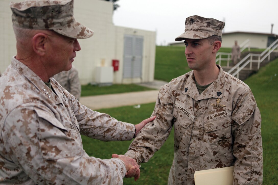 Sgt. Daniel R. Luntzel receives personal congratulations from Lt. Gen. Kenneth J. Glueck Jr. on Camp Courtney May 4. Luntzel was awarded a scholarship to Colgate University, in Hamilton, New York, as part of Colgate's leadership scholar program. Luntzel is an instructor with Special Operations Training Group, III Marine Expeditionary Force Headquarters Group, III MEF. Glueck is the commanding general of III MEF.
