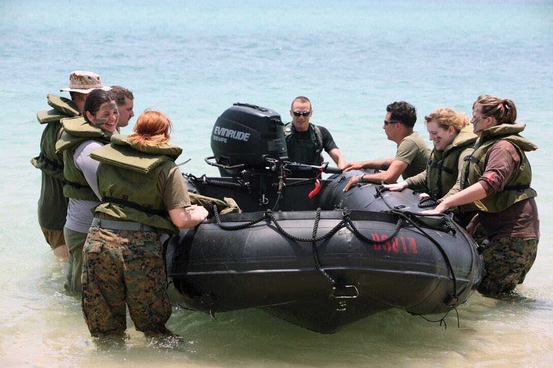 Marine spouses prepare to ride in a combat rubber raiding craft during spouses' warrior day on Camp Hansen May 11. 
