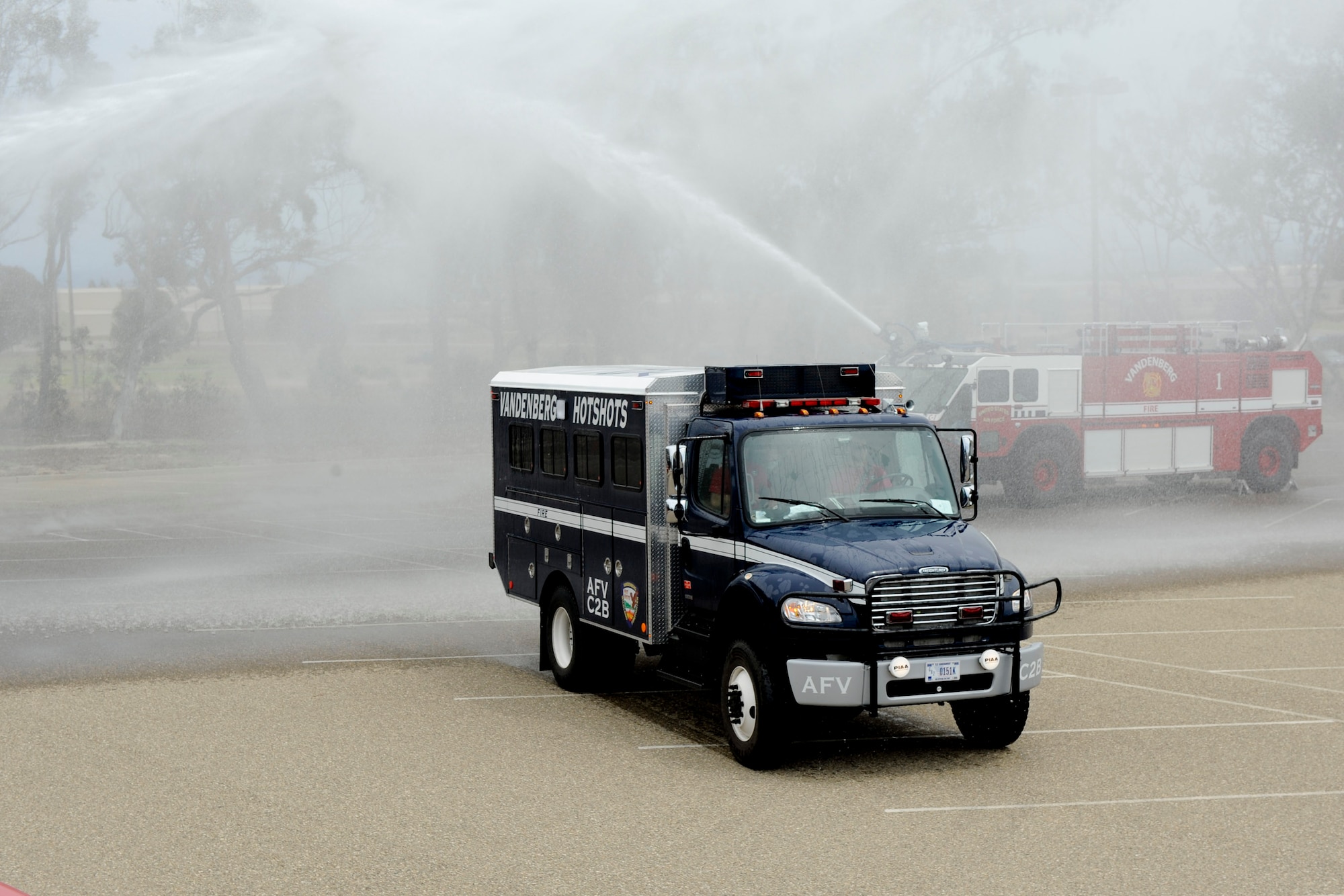 VANDENBERG AIR FORCE BASE, Calif. -- A Vandenberg Hot Shots crew vehicle is doused by fire trucks as it arrives at the Pacific Coast Club here after returning from fighting wildfires in Colorado and Wyoming Thursday, July 12, 2012. Wildfires in Colorado and Wyoming burned 29,168 acres total and destroyed nearly 350 houses in Colorado. (U.S. Air Force photo/Staff Sgt. Levi Riendeau)