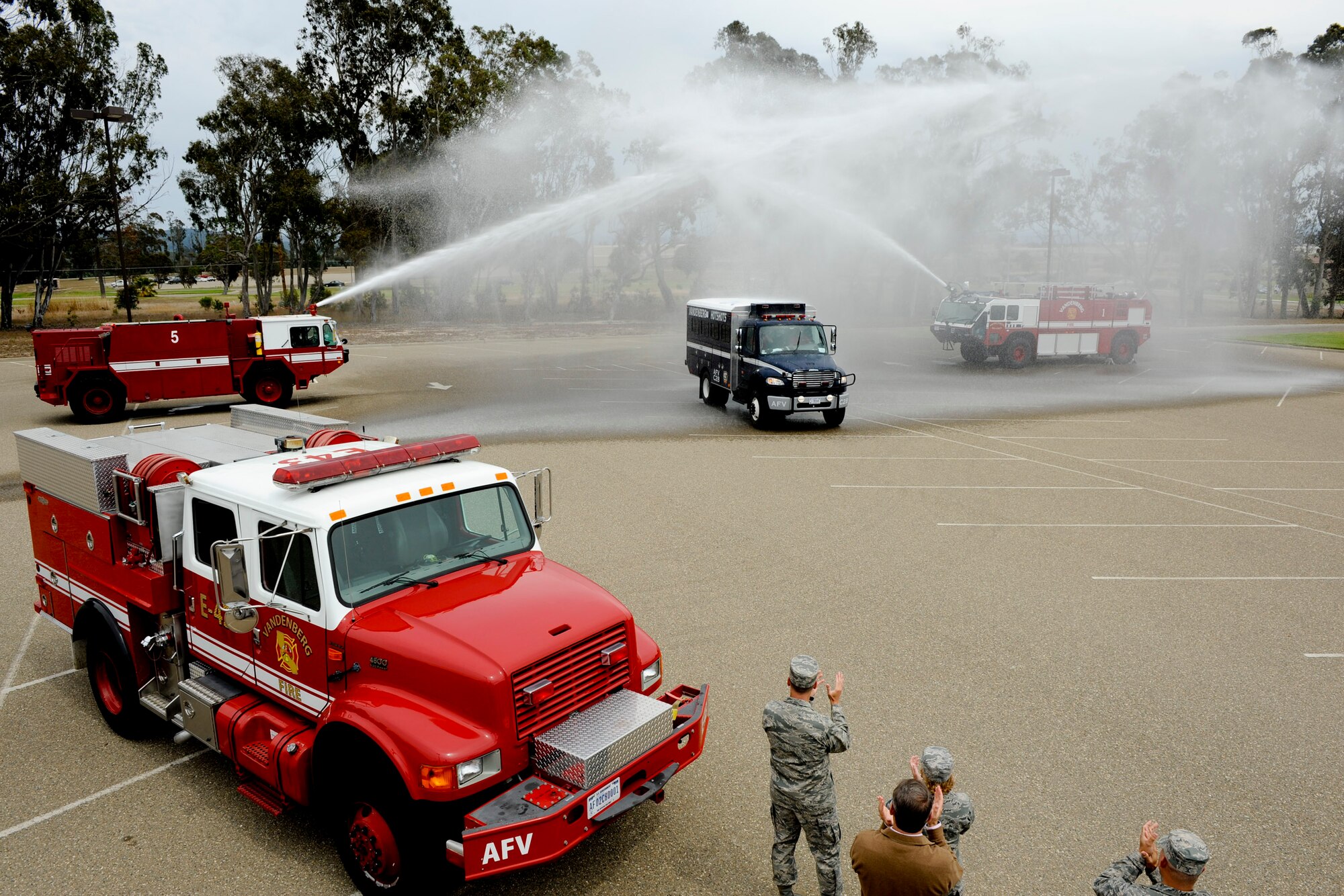 VANDENBERG AIR FORCE BASE, Calif. -- A Vandenberg Hot Shots crew vehicle is doused by fire trucks as it arrives at the Pacific Coast Club here after returning from fighting wildfires in Colorado and Wyoming Thursday, July 12, 2012. Wildfires in Colorado and Wyoming burned 29,168 acres total and destroyed nearly 350 houses in Colorado. (U.S. Air Force photo/Staff Sgt. Levi Riendeau)