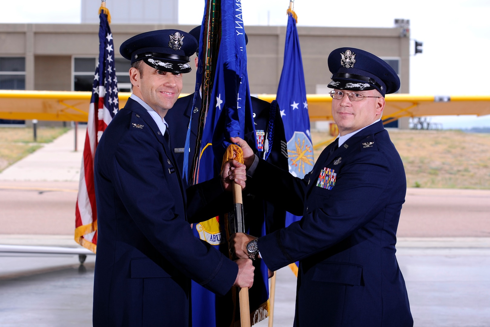 Col. Joseph Rizzuto, right, accepts the guidon and command of  the 306th Flying Training Group from Col. Gerald Goodfellow, 12th Flying Training Wing commander, during a change of command ceremony July 9. Rizzuto replaces Col. Christopher Plamp, who is headed to the NATO Combined Air Operations Center in Uedem, Germany, where he will be the Director of Operations and Commander of the U.S. Element there. (U.S. Air Force Photo/Mike Kaplan)