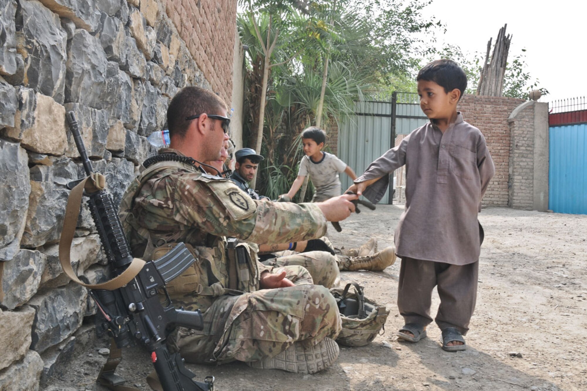 Lins greets a local Afghan boy inside a qalat of a female school in the village of Mangas July 7. (U.S. Army photo/Staff Sgt. Jason Epperson)