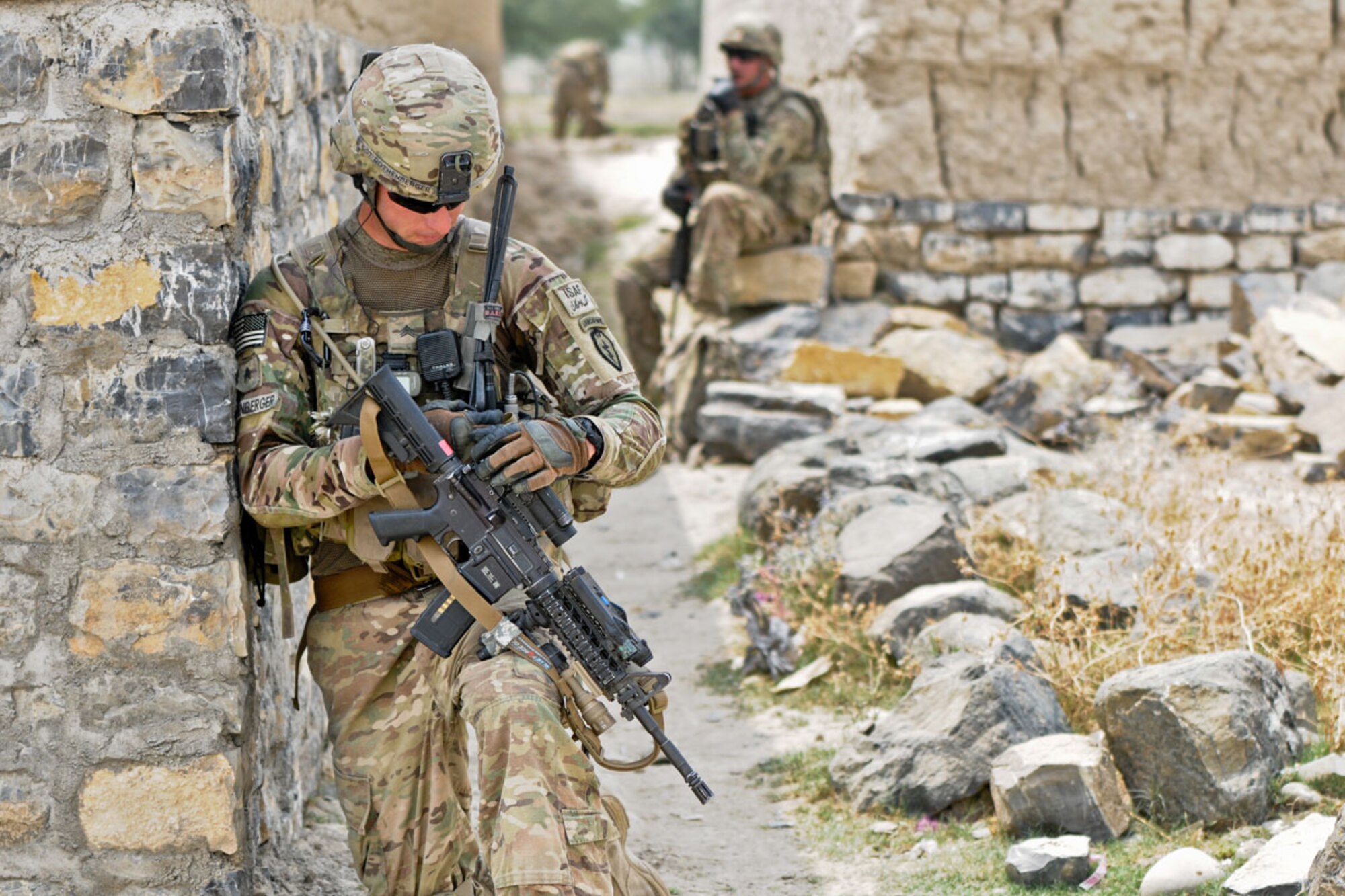 Sgt. Eric Rothenberger, a native of Phoenix, and team leader assigned to A Battery, 2nd Battalion (Airborne), 377th Parachute Field Artillery Regiment, Task Force Spartan Steel, checks his sights while pulling security at an alleyway in the village of Kunday July 7. The unit’s mission was to facilitate members of the 2-377th PFAR Female Engagement Team as they conducted key leader engagements to promote a female health-education program. (U.S. Army photo/Staff Sgt. Jason Epperson)