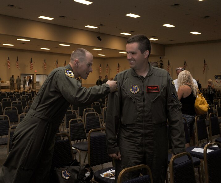1st Lt. Paul Gabor, 11th Bomb Squadron Formal Training Unit, punches a unit patch on the flight suit of Capt. Seth Shipley, 96th Bomb Squadron, after graduating from his FTU class on Barksdale Air Force Base, La., July 10. FTU is a nine month course for pilots, navigators and electronic warfare officers out of their initial flight training. The course consists of academic studies, simulators and flight training where the students gain the experience and confidence to operate a B-52H Stratofortress. (U.S. Air Force photo/Airman 1st Class Benjamin Gonsier)(RELEASED)