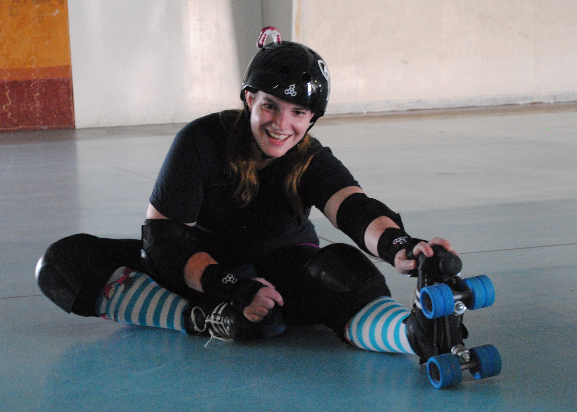 Staff Sgt. Jacqueline Moore, 341st Missile Wing command post senior emergency action controller, a member of the Electric City Roller GrrrlZ since January, stretches her legs after practice. (U.S. Air Force photo/Airman 1st Class Katrina Heikkinen)
