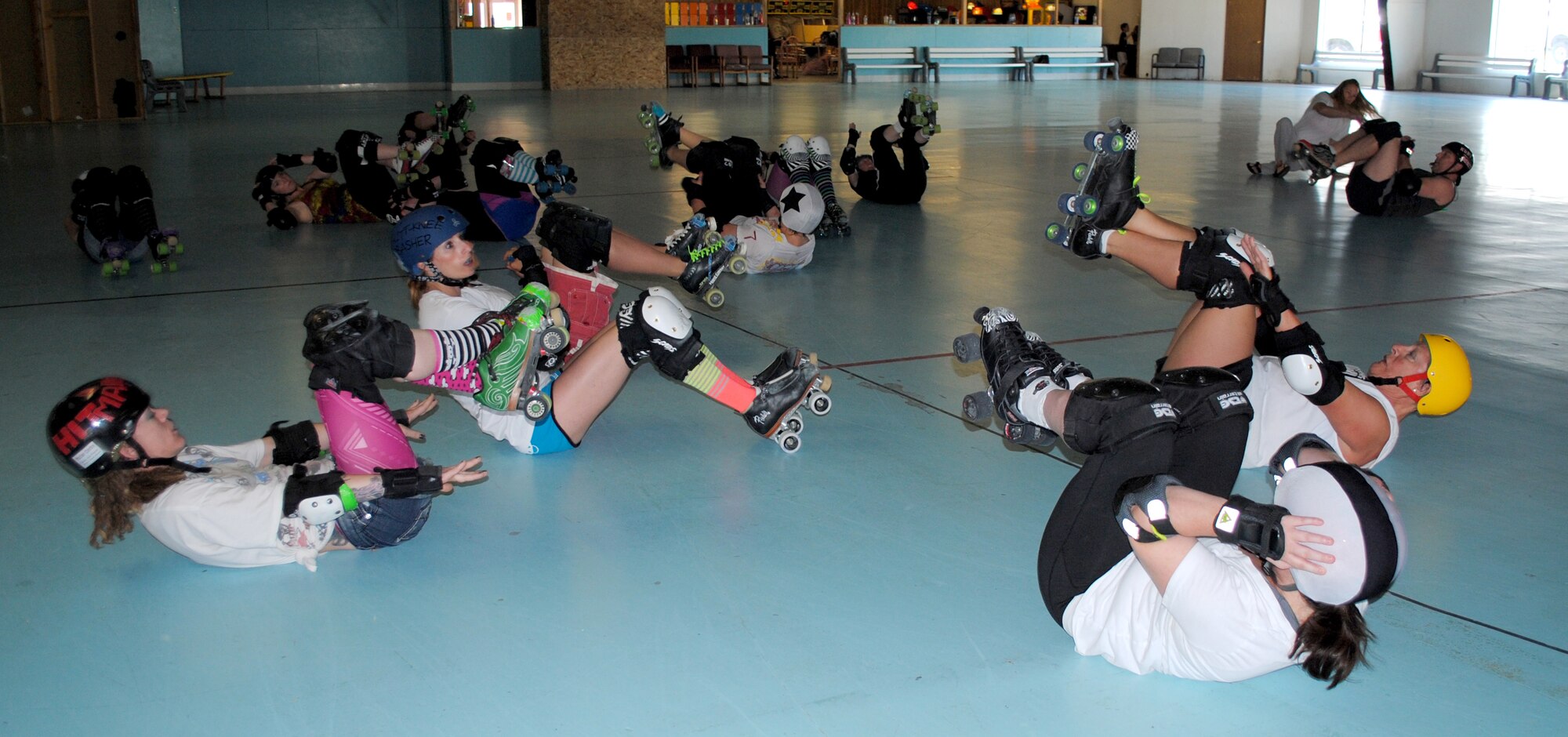 Electric City Roller GrrrlZ work on their fitness by doing sit-ups to wrap up their 2-hour practice at Hauers Family Skating Center on June 24. More than 25 women practice twice a week, but only 15 members will be selected to compete in a bout. (U.S. Air Force photo/Airman 1st Class Katrina Heikkinen) 