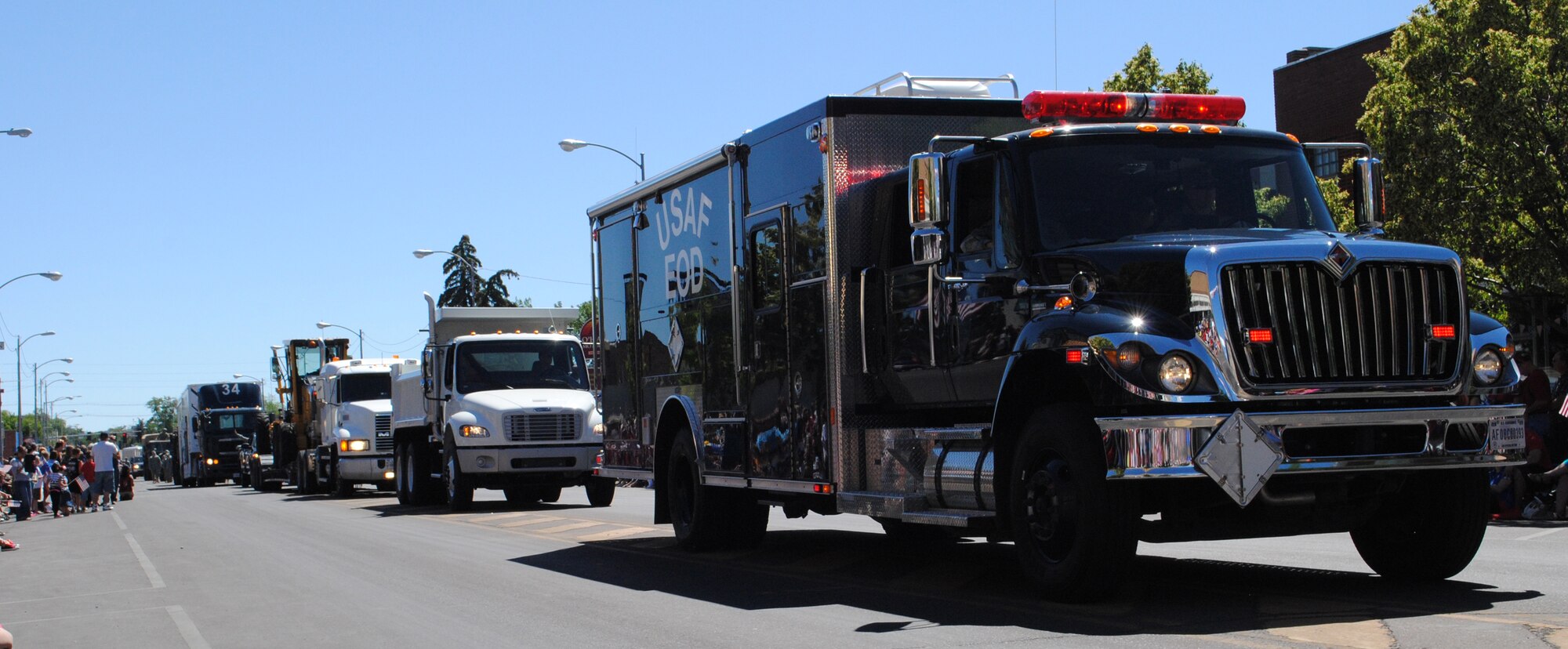 Malmstrom’s Explosive Ordnance Disposal truck leads a line of several vehicles used on base in the Fourth of July parade.  Following it included a few heavy equipment vehicles used at the 819th RED HORSE Squadron, a security forces suburban and a payload transporter.  (U.S. Air Force photo/Airman 1st Class Cortney Paxton)