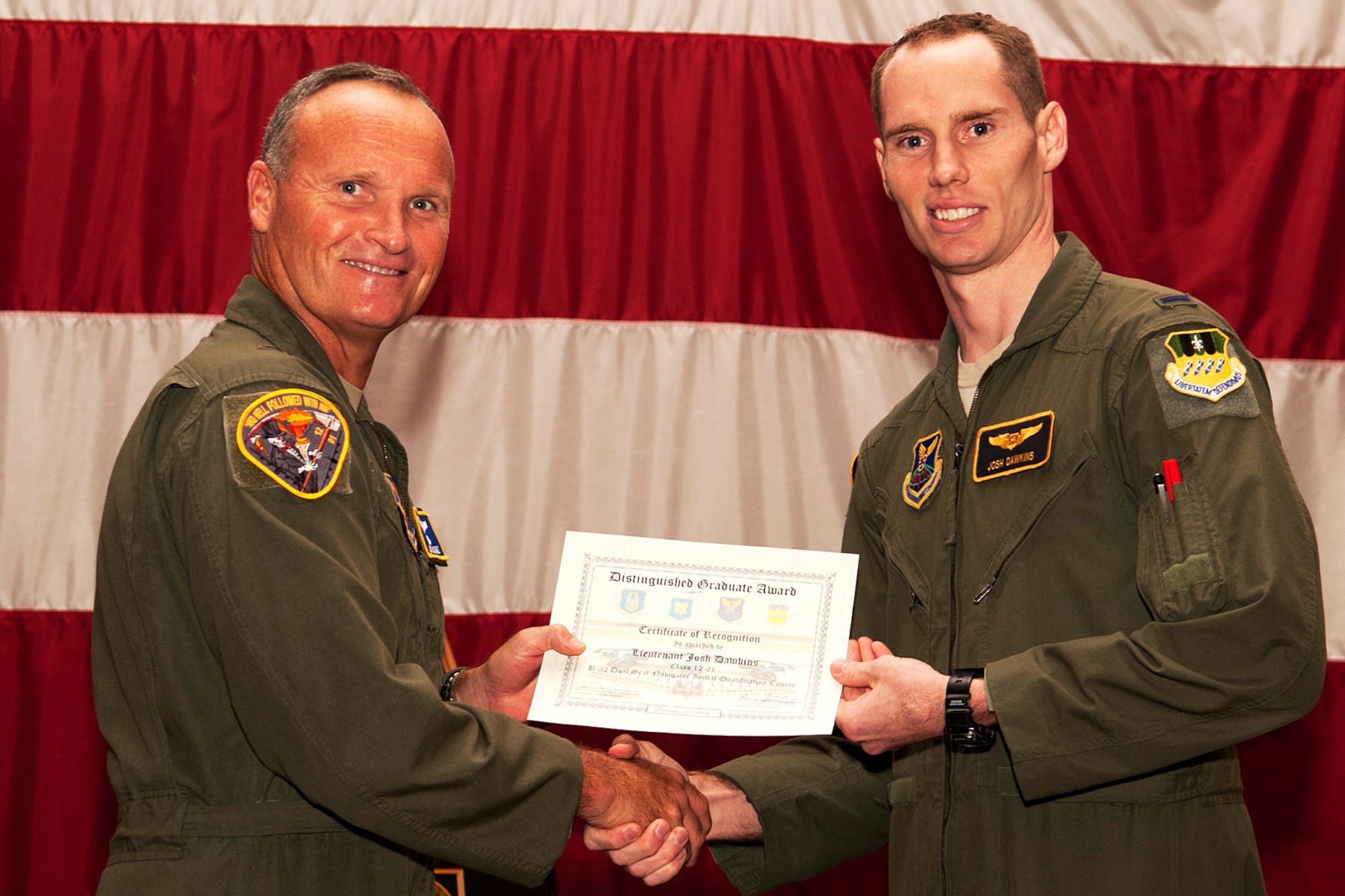 U.S. Air Force Brig. Gen. James Brown, Air Force Global Strike Command director of operations, presents the Dual Seat Navigator Distinguished Graduate certificate to 1st Lt. Josh Dawkins during a graduation ceremony on Barksdale Air Force Base, La., July 10, 2012. Dawkins was also recognized for achieving an overall academic average of 99.75 percent. (U.S. Air Force photo by Master Sgt. Greg Steele/Released)