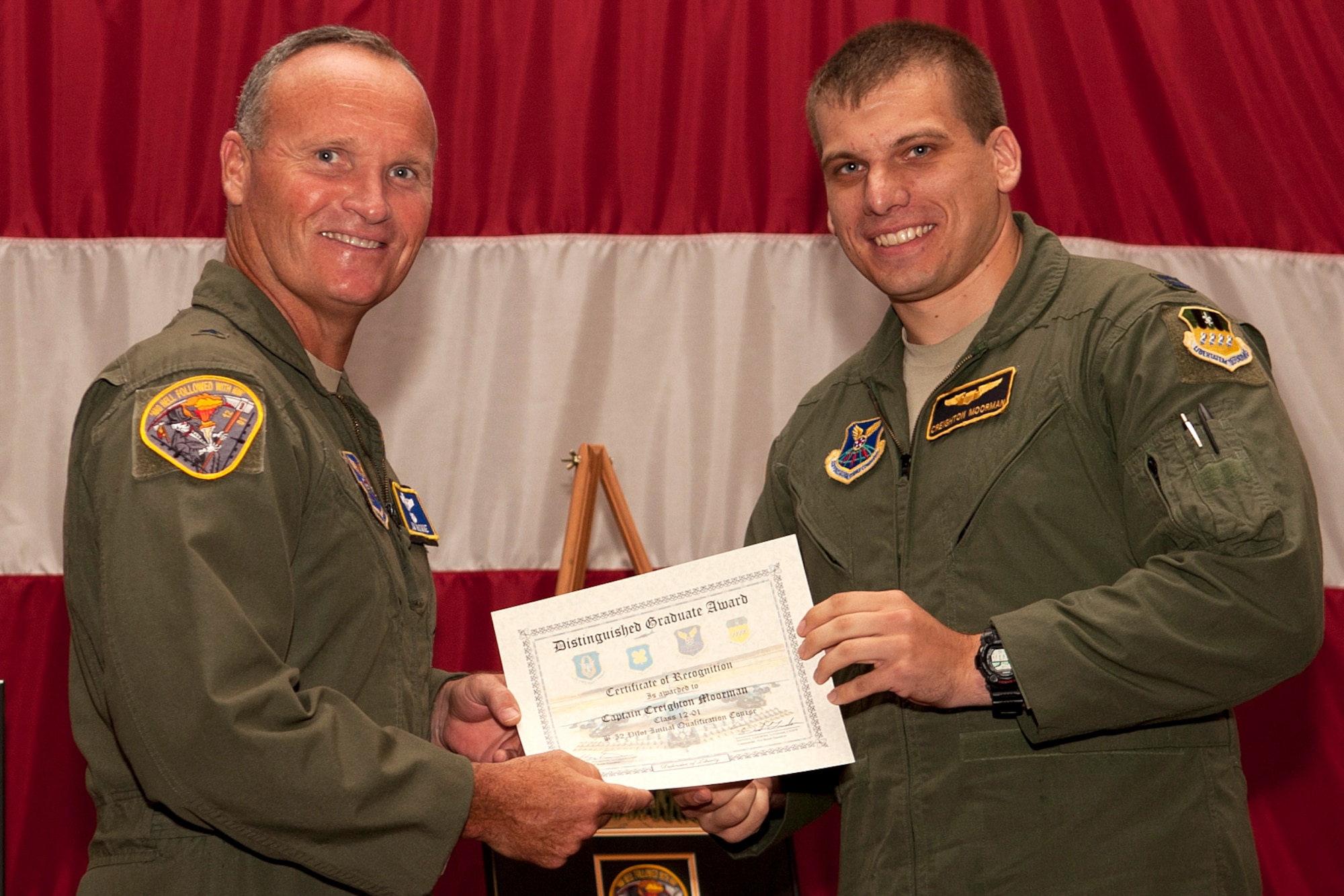 U.S. Air Force Brig. Gen. James Brown, Air Force Global Strike Command director of operations, presents the Copilot Distinguished Graduate certificate to Capt. Creighton Moorman during a graduation ceremony on Barksdale Air Force Base, La., July 10, 2012. Moorman was also recognized for achieving an overall academic average of 99 percent. (U.S. Air Force photo by Master Sgt. Greg Steele/Released)