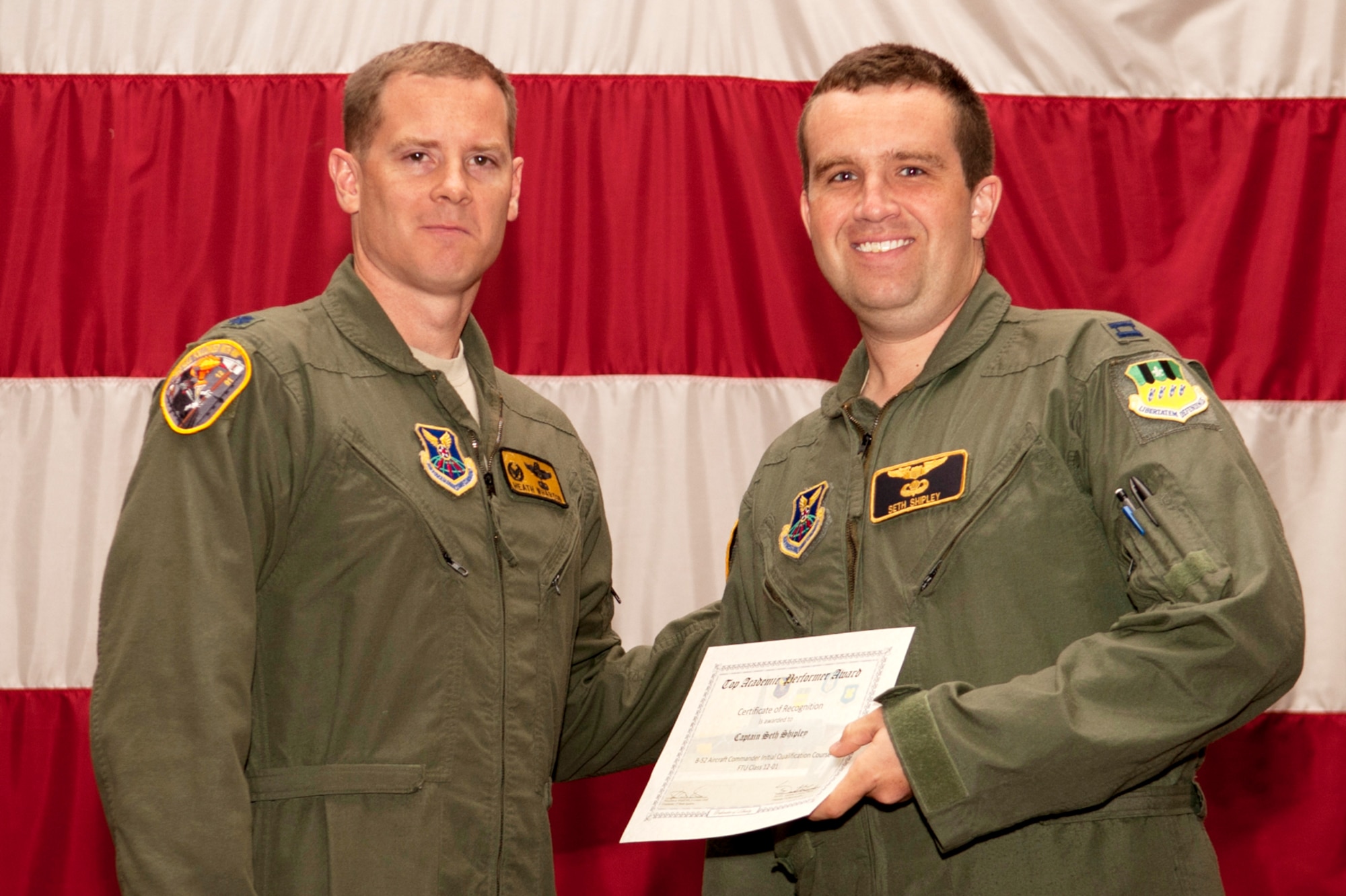 U.S. Air Force Lt. Col. William Wharton, 11th Bomb Squadron commander, presents the Aircraft Commander Outstanding Academic Performer certificate to Capt. Seth Shipley during a graduation ceremony on Barksdale Air Force Base, La., July 10, 2012. Shipley graduated from the Formal Training Unit at Barksdale where he spent nine months learning to fly the B-52H Stratofortress and achieved an overall academic average of 98.71 percent. (U.S. Air Force photo by Master Sgt. Greg Steele/Released)