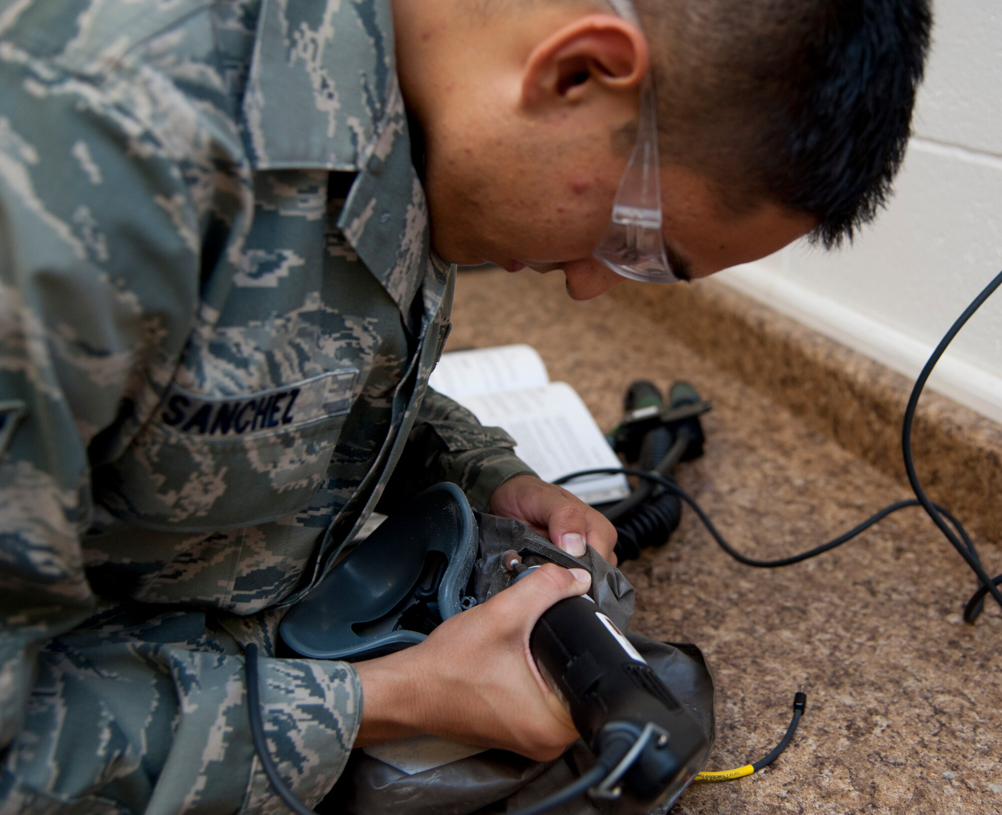 Airman 1st Class Abraham Sanchez, 6th Air Refueling Squadron aircrew flight equipment journeyman, sands down a mask July 10, 1012, that a C-17 Globemaster III pilot wears during flight. Aircrew flight equipment personnel issue, fit, repair, and maintain human-side flight equipment such as parachutes, helmets, oxygen equipment, anti-gravity garments, anti-exposure suits, aircrew ocular devices, survival kits, life preservers, rafts, electronic communications, helmet mounted weapons integration devices, and aircrew Chemical, Biological, Radiological, Nuclear equipment. (U.S. Air Force photo/Airman 1st Class Nicole Leidholm)