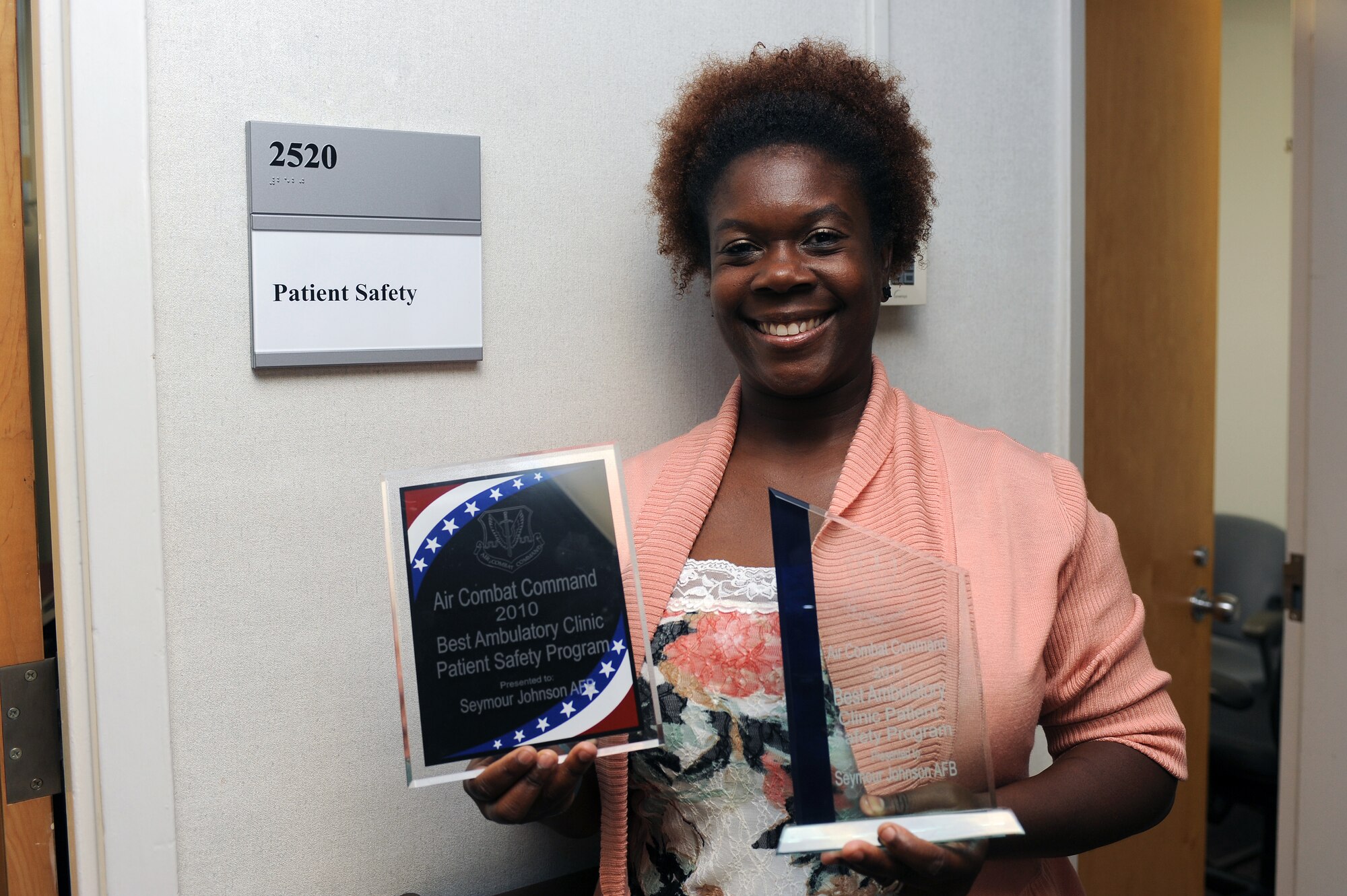 Tasha Hunter, 4th Medical Group patient safety manager, holds up the 2010 and 2011 awards for the Air Combat Command Best Ambulatory Clinic Patient Safety Program, at the 4th Medical Group Military Treatment Facility on Seymour Johnson Air Force Base, N.C., July 11, 2012. The patient safety program prevents harm to patients and reduces medical errors by receiving reports of successful error intervention in patient care. (U.S. Air Force photo/Airman 1st Class John Nieves Camacho/Released)
