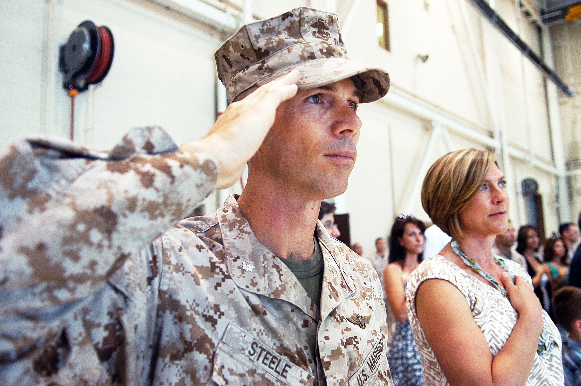 Lt. Col. David M. Steele and his wife Tracy pay their respects to the flag during the playing of the national anthem  during a change of command ceremony where he assumed command of Marine Aircraft Group 49, Det. A, Monday.  (U. S. Air Force photo/Sue Sapp)