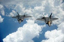 A pair of F-22 Raptors pulls away and flies behind a KC-135 Stratotanker after receiving fuel off of the East Coast on July 10, 2012. The 1st Fighter Wing at Joint Base Langley-Eustis, Va., received their first two Raptors in January 2005 and the wing’s 27th Fighter Squadron was designated as fully operational in December 2005. The Raptors belong to the 27th FS and the KC-135 belongs to the 756th Air Refueling Squadron at Joint Base Andrews, Md. (U.S. Air Force photo/Master Sgt. Jeremy Lock)