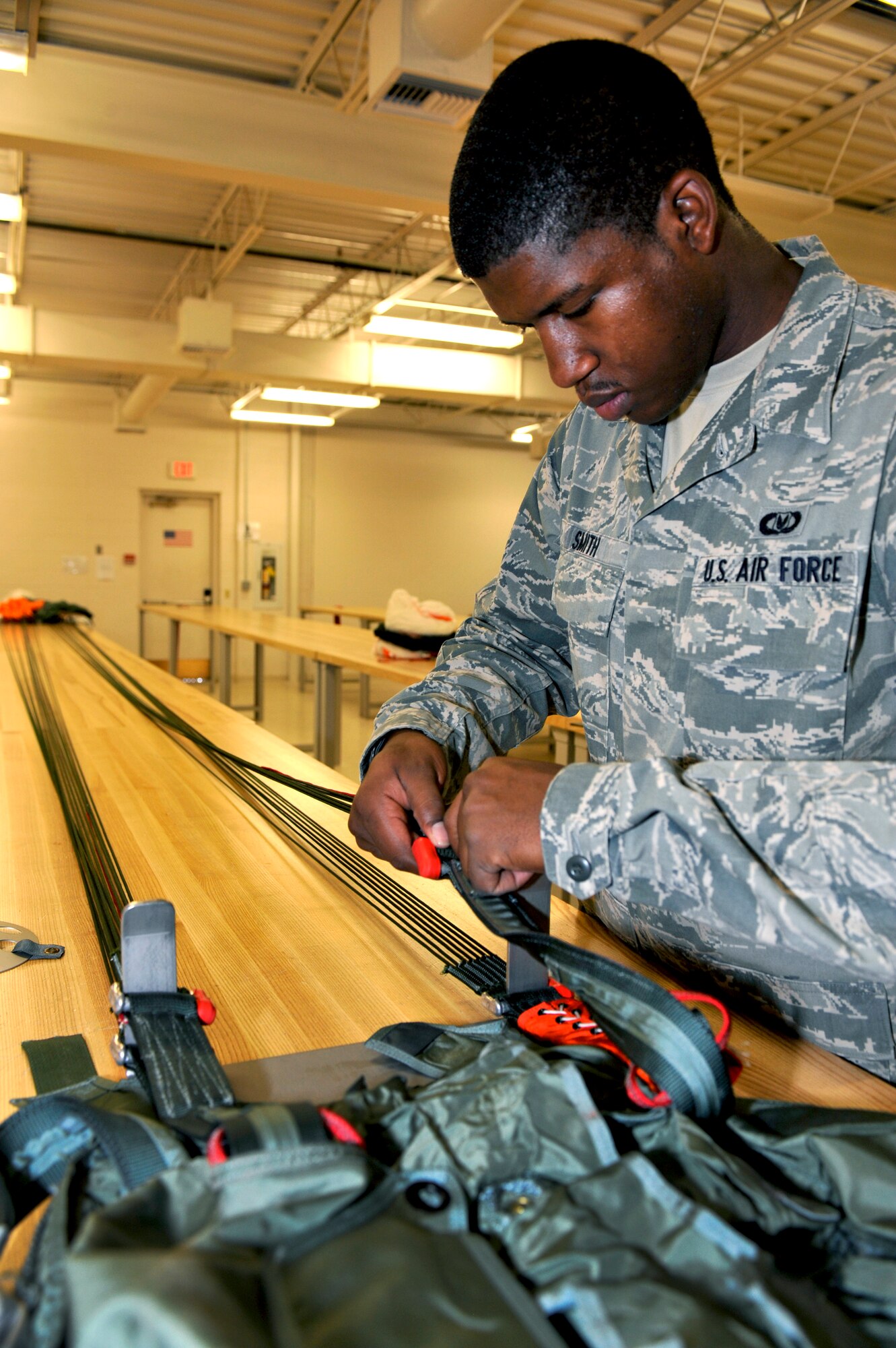 U.S. Air Force Airman 1st Class Zachary Smith, 27th Special Operations Support Squadron aircrew flight equipment apprentice, repairs a parachute while working in the aircrew flight equipment shop at Cannon Air Force Base, N.M., July 9, 2012. This shop repairs all emergency flight equipment and trains aircrew on their usage. (U.S. Air Force photo by Airman 1st Class Ericka Engblom)
