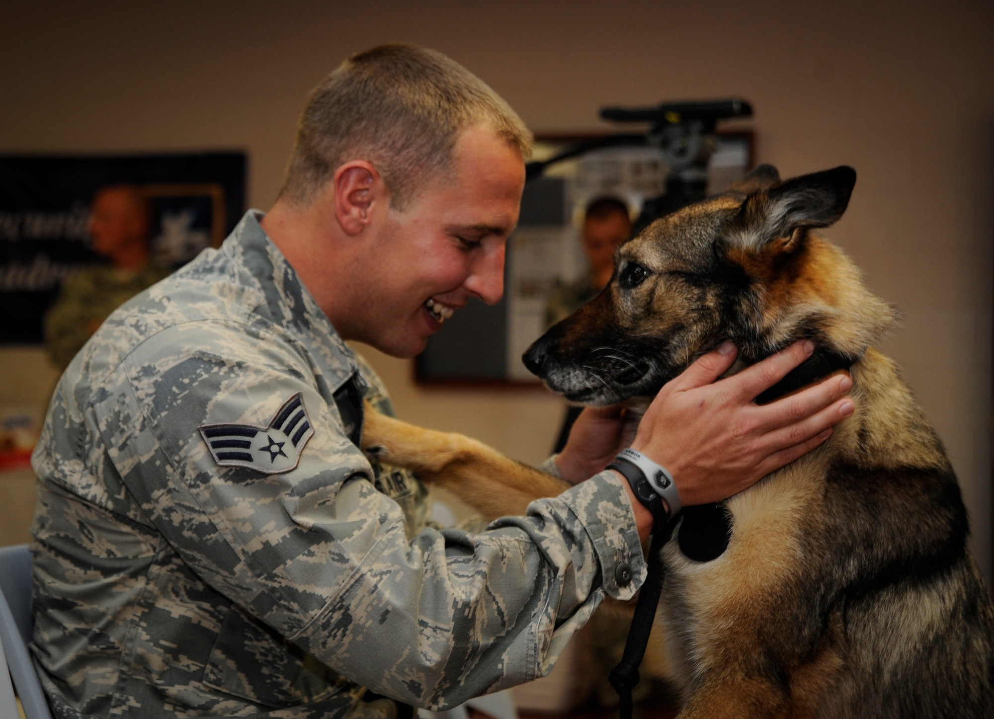Senior Airman Brandon Denton, 6th Security Forces Squadron military working dog handler, plays with his partner, Conny prior to her retirement ceremony at MacDill Air Force Base, Fla., July 12, 2012. Denton and Conny have been partners for two years, and upon her retirement was adopted by Denton. (U.S. Air Force photo by Staff Sgt. Linzi Joseph/Released/cropped to point of interest)