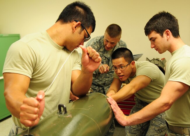 Tech. Sgt. Charles Woodland, 9th Munitions Squadron instructor, directs as (Center) Air Force Academy Cadet John Lu, from Novi, Mich., feeds a wire while building a 500 pound bomb July 11, 2012 at Beale Air Force Base, Calif. Groups of cadets are visiting Beale and other bases throughout the summer to get a taste of Air Force careers and the military lifestyle. (U.S. Air Force photo by Senior Airman Shawn Nickel/Released)