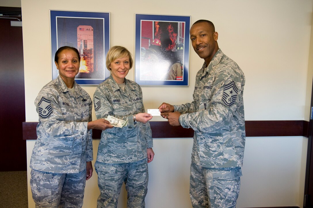 Senior Master Sgt. Sylvia Morris and Master Sgt. Agnes Bradt from the Space Coast
Top 3 Association sell a ticket to the 2012 Senior Noncommissioned Offi cer Induction
Ceremony to Chief Master Sgt. Herman Moyer, 45th Space Wing command chief master sergeant.  The ceremony is scheduled for July 20. (Photo by Jule Dayringer)