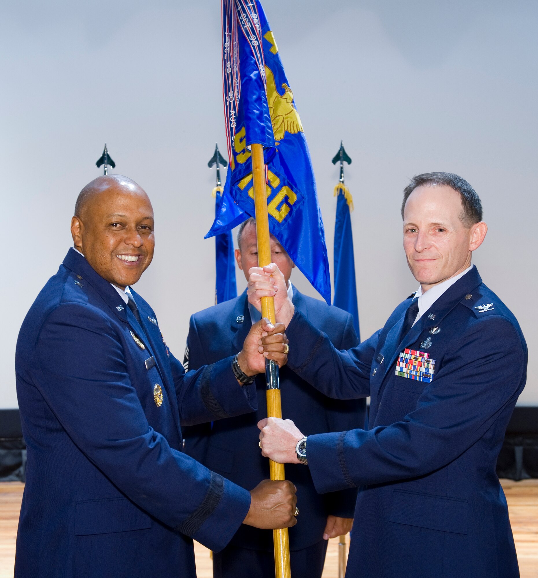 Brig. Gen. Anthony Cotton, 45th Space Wing commander, passes the 45th Mission Support Group guidon to its new commander, Col. Patridk Donley, during a change of command ceremony July 6. Colonel Donley is  a recent graduate of the U.S. Air War College at Maxwell AFB, Ala. (Photo by Matthew Jurgens)