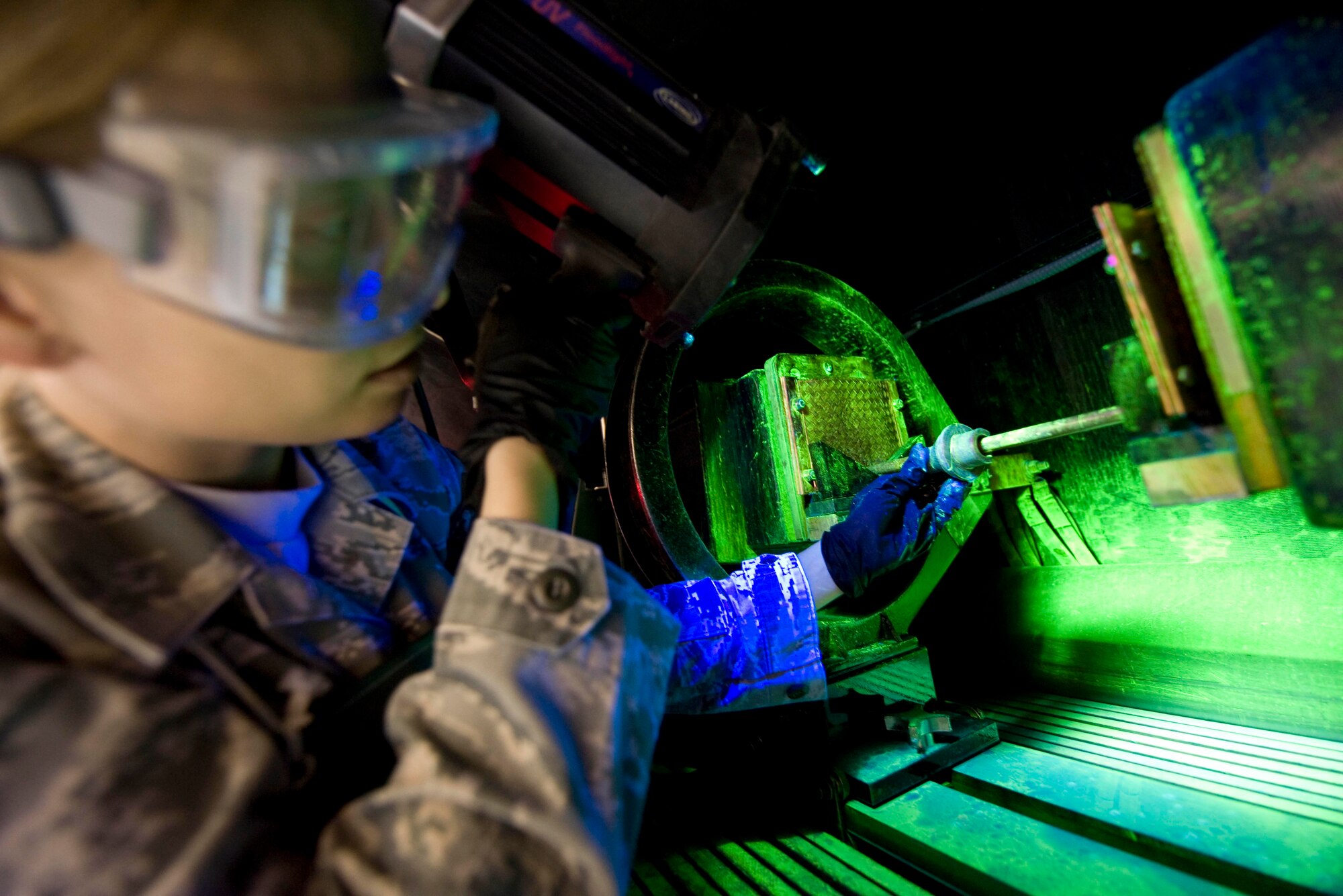U.S. Air Force Staff Sgt. Rebeca Linden de Romero, 379th Expeditionary Maintenance Squadron Non-Destructive Inspection technician, checks for any discrepancy on an aircraft component by performing a magnetic particle inspection in Southwest Asia, July 11, 2012. A magnetic particle inspection reveals any surface and subsurface defects of magnetic metal items. Linden de Romero is deployed from Travis Air Force Base, Calif., and is a native of Durango, Mexico. (U.S. Air Force photo/Staff Sgt. Sheila deVera)