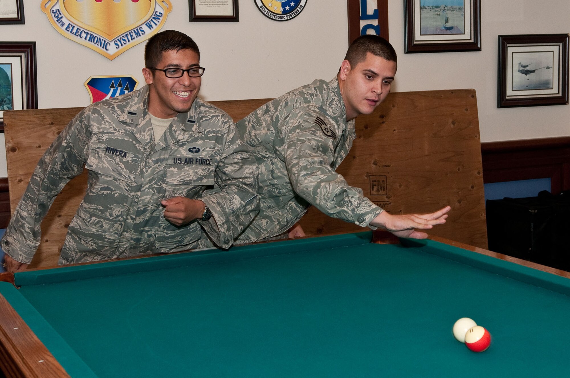 HANSCOM AIR FORCE BASE, Mass. – 1st Lt. Robert Rivera (left) attempts to bump Staff Sgt. Chase Ryan as he takes his shot during the CRUD Tournament at the Minuteman Commons July 6. In addition to the tournament, the Commons hosted First Friday activities with live music and more.  (U.S. Air Force photo by Mark Herlihy)