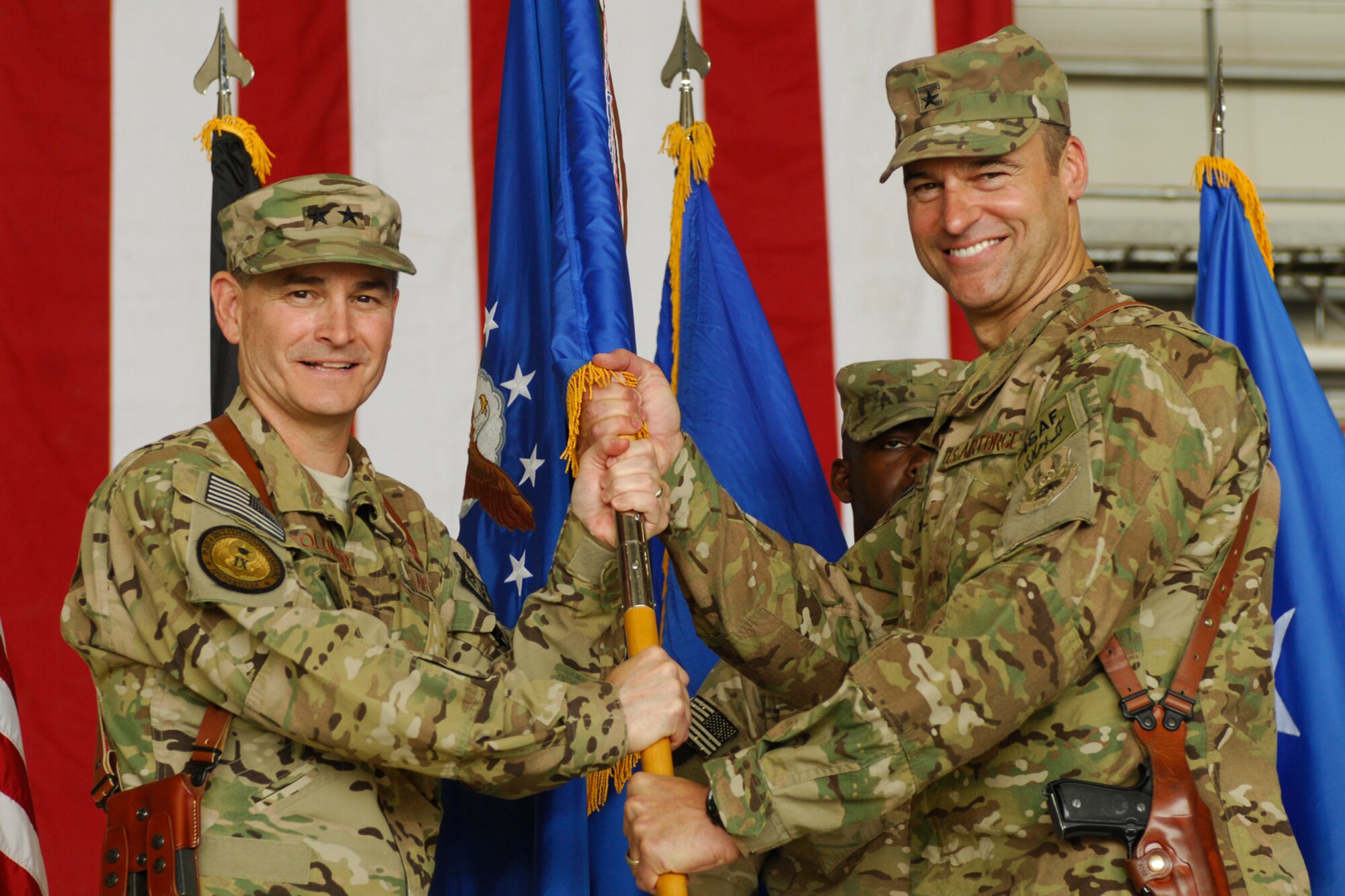 Maj. Gen. H. D. Polumbo, 9th Air and Space Expeditionary Task Force-Afghanistan commander, presents the 455th Air Expeditionary Wing guidon to Brig. Gen. Joseph Guastella as he assumes command of the 455 AEW at Bagram Airfield, Afghanistan, July 12, 2012. Guastella is now responsible for approximately 2, 000 Airmen assigned to the wing. (U.S. Air Force photo/SSgt. Jeff Nevison)