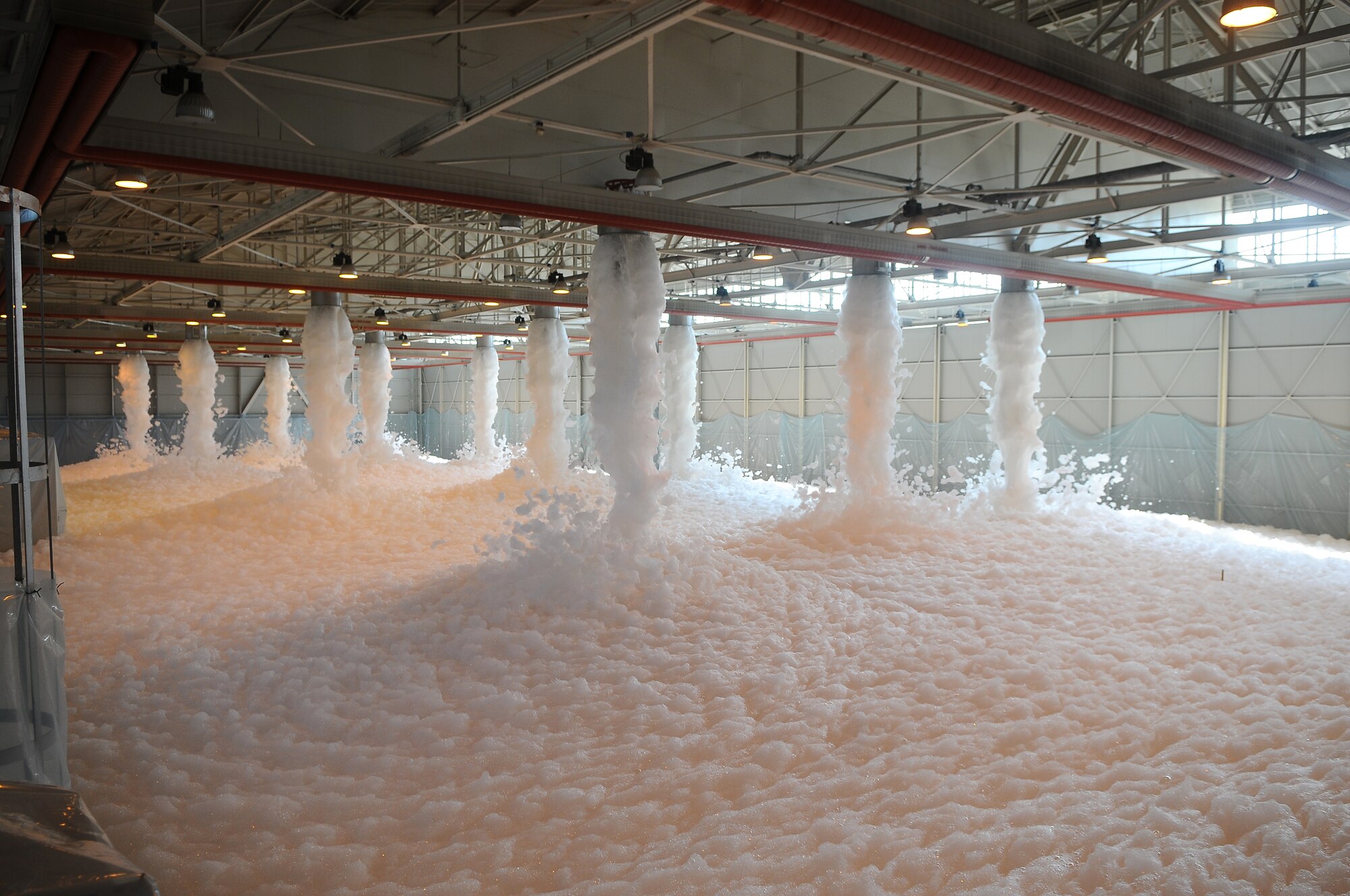 Officials test a newly-completed fire suppressant system in Hangar 3 July 11 at Aviano Air Base, Italy. The system is used to protect aircraft house within the hangar in case of a fire. Once heat sensors are activated, the system has the ability to fill the football-field sized hangar with one-meter thick foam in four minutes or less. (U.S. Air Force photo/Senior Airman Katherine Windish)
 
