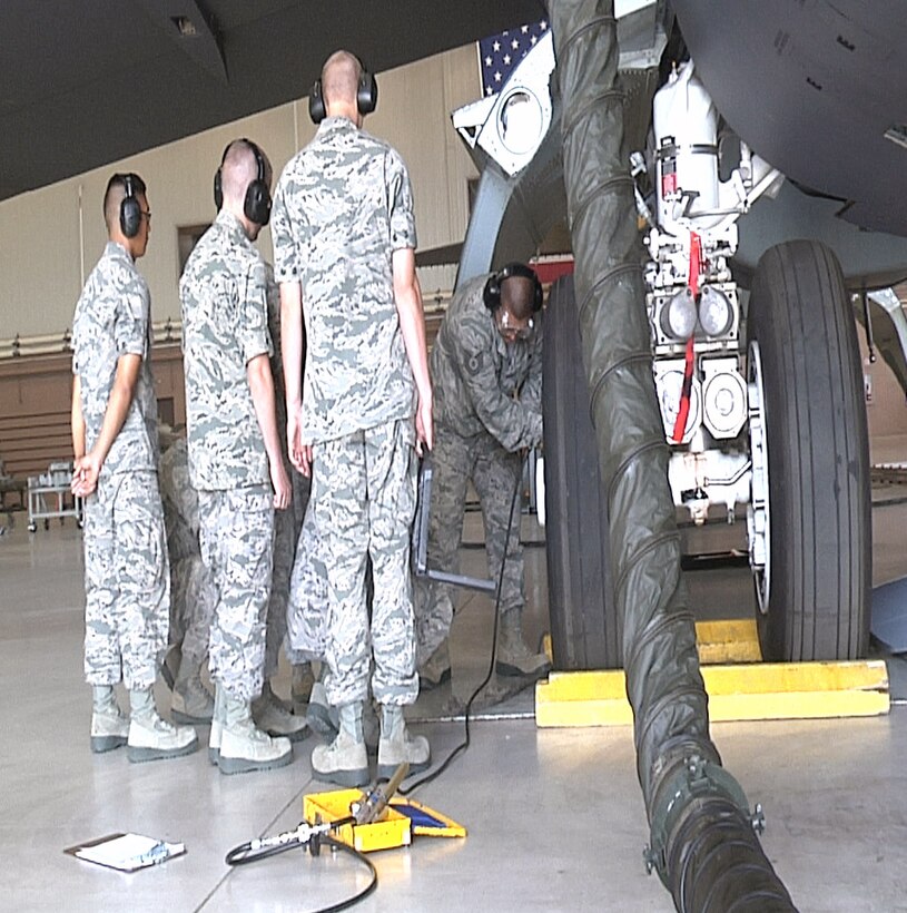 Tech Sgt. Kendall Lizama of the 362nd TRS demonstrates the proper procedure for doing a maintenance check on a tire of a B-52.  The 362nd TRS B-52 Aerospace Maintenance Apprentice course teaches Airmen the fundamentals of becoming a B-52 Crew Chief. (U.S. Air Force Photo/Josh Wilson)