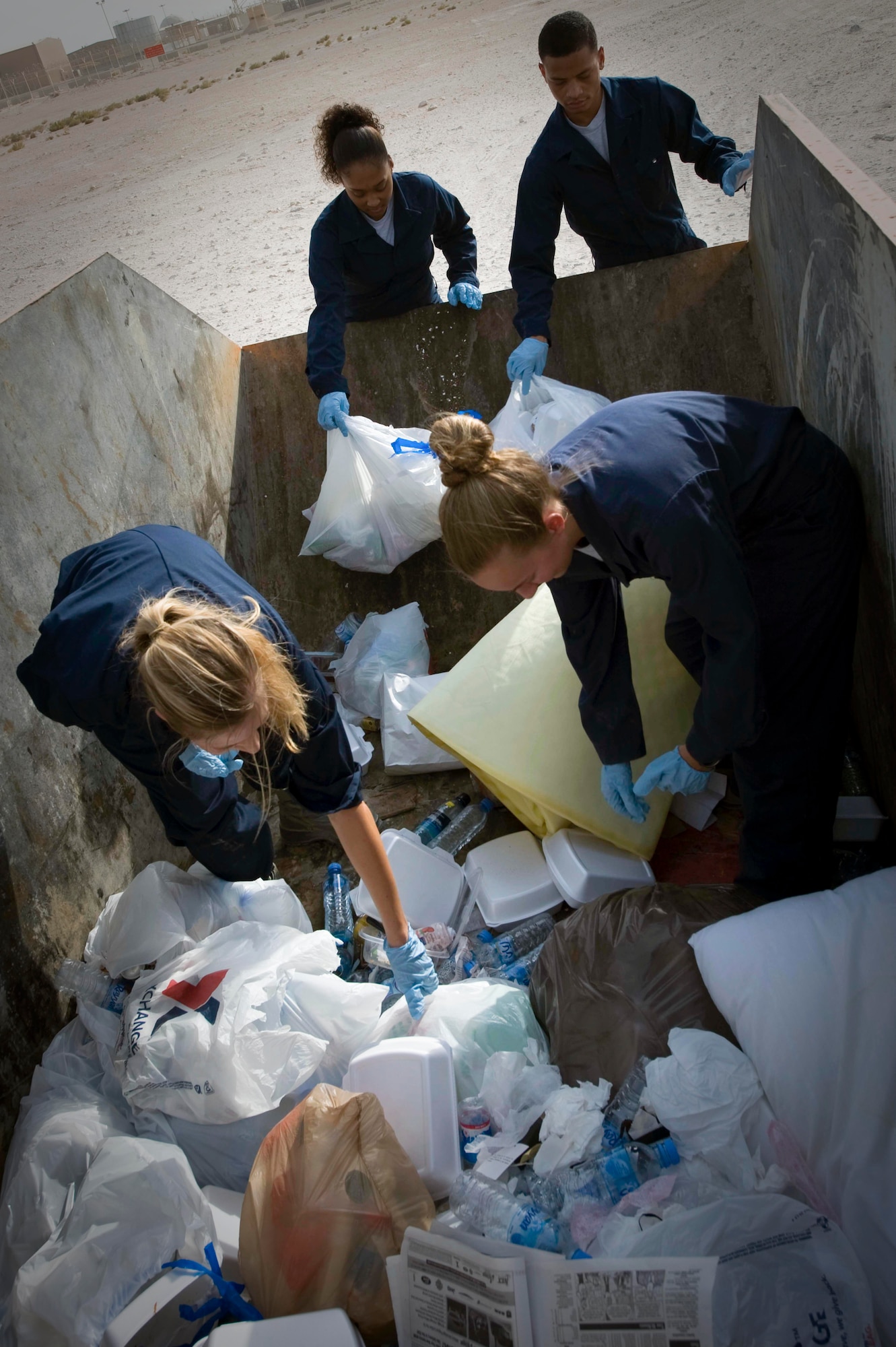 Members from the Escort Flight - Tango Element also known as ?Dumpster Divers? sort through trash looking for operation security violations in Southwest Asia, July 2, 2012. Last month alone, Tango Element recovered more than 1,900 OPSEC violations. Airmen from Tango Element are assigned to the 379th Expeditionary Civil Engineer Squadron. (U.S. Air Force photo/Staff Sgt. Sheila deVera)