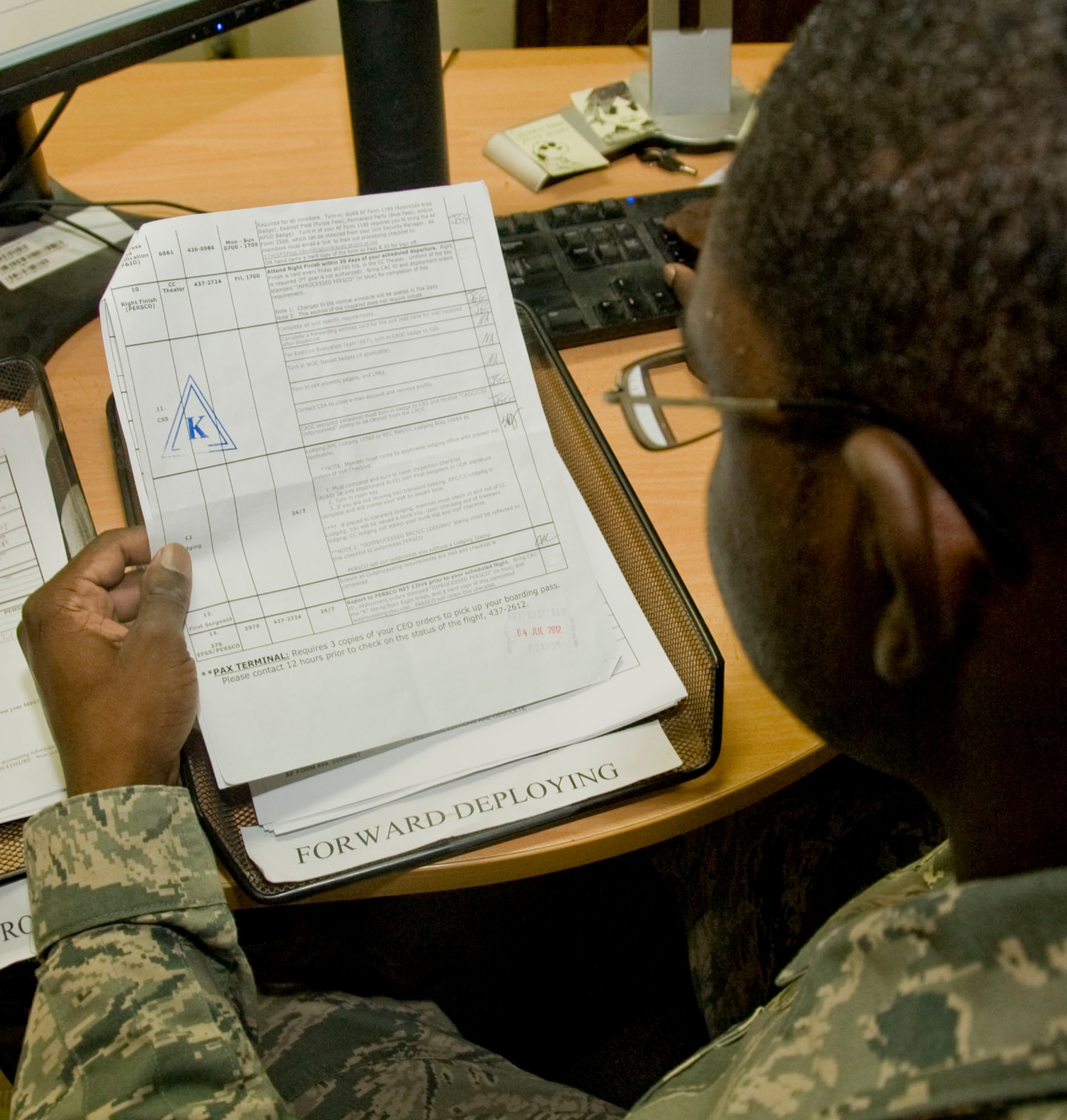 Senior Airman Deltron McRae, assigned to the 379th Expeditionary Force Support Squadron Deliberate and Crisis Action Planning and Execution Segments section, reviews an out-processing checklist in Southwest Asia July 10, 2012. DCAPES primarily provides the Air Force with end-to-end personnel accountability and gives PERSCO members the ability to monitor the duty status of all deployed Airmen throughout the world. (U.S. Air Force photo/Senior Airman Bryan Swink)