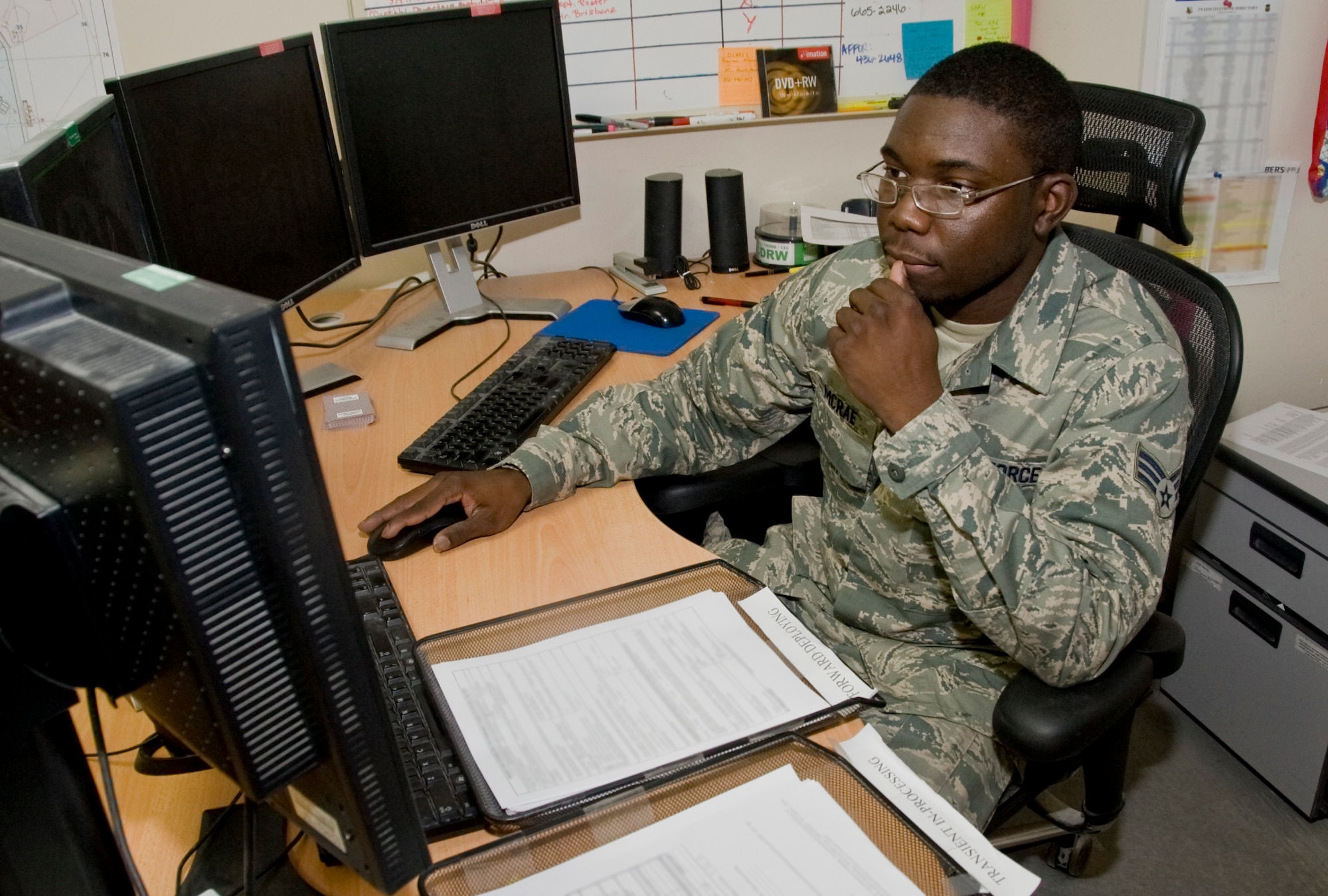 Senior Airman Deltron McRae, assigned to the 379th Expeditionary Force Support Squadron’s Deliberate and Crisis Action Planning and Execution Segments section, in-processes new arrivals to the installation July 10, 2012. The DCAPES team processes approximately 30,000 people here during their six-month rotation. (U.S. Air Force photo illustration/Senior Airman Bryan Swink)