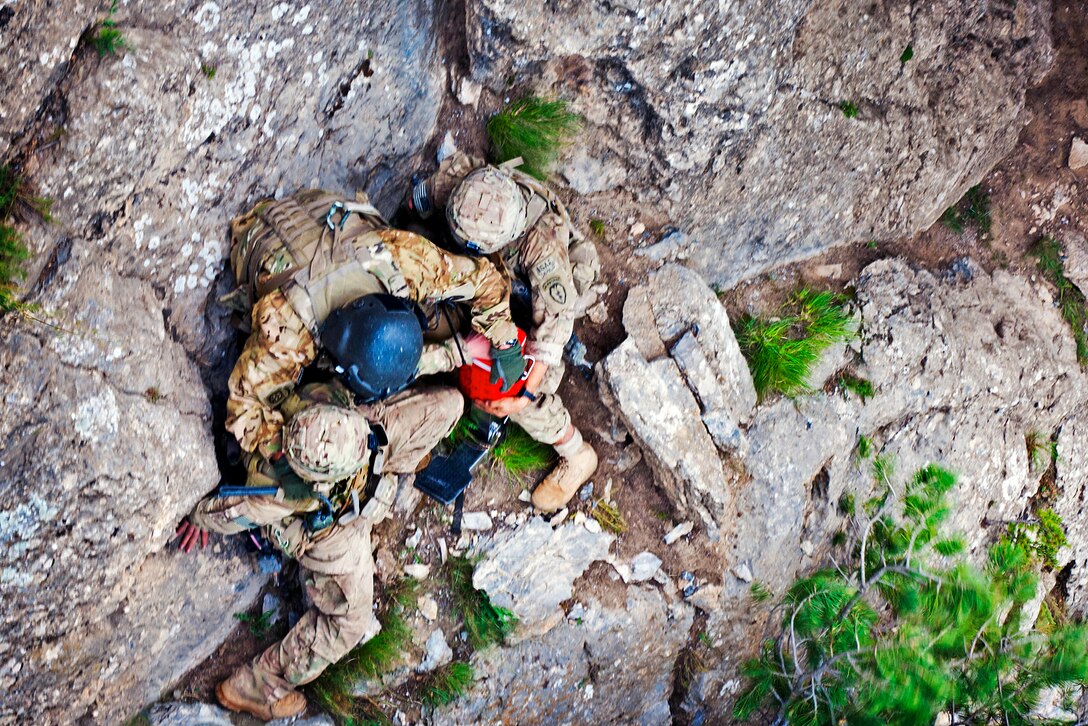 U.S. Army Staff Sgt. Patrick Rogers, center, helps U.S. Army Pfc. Michael Halberg and U.S. Army Staff Sgt. Ryan Stumpff hook up to extraction equipment as they prepare to be rescued from a mountainside in Afghanistan's Khowst province, July 4, 2012. Halberg and Stumpff are assigned to the 25th Infantry Division's 4th Brigade Combat Team, and were stranded on a narrow ledge above a 50-foot drop while escaping an enemy ambush. A dual-state U.S. National Guard unit assigned to the 82nd Combat Aviation Brigade rescued the two soldiers with a hoist attached to their UH-60 Black Hawk helicopter.