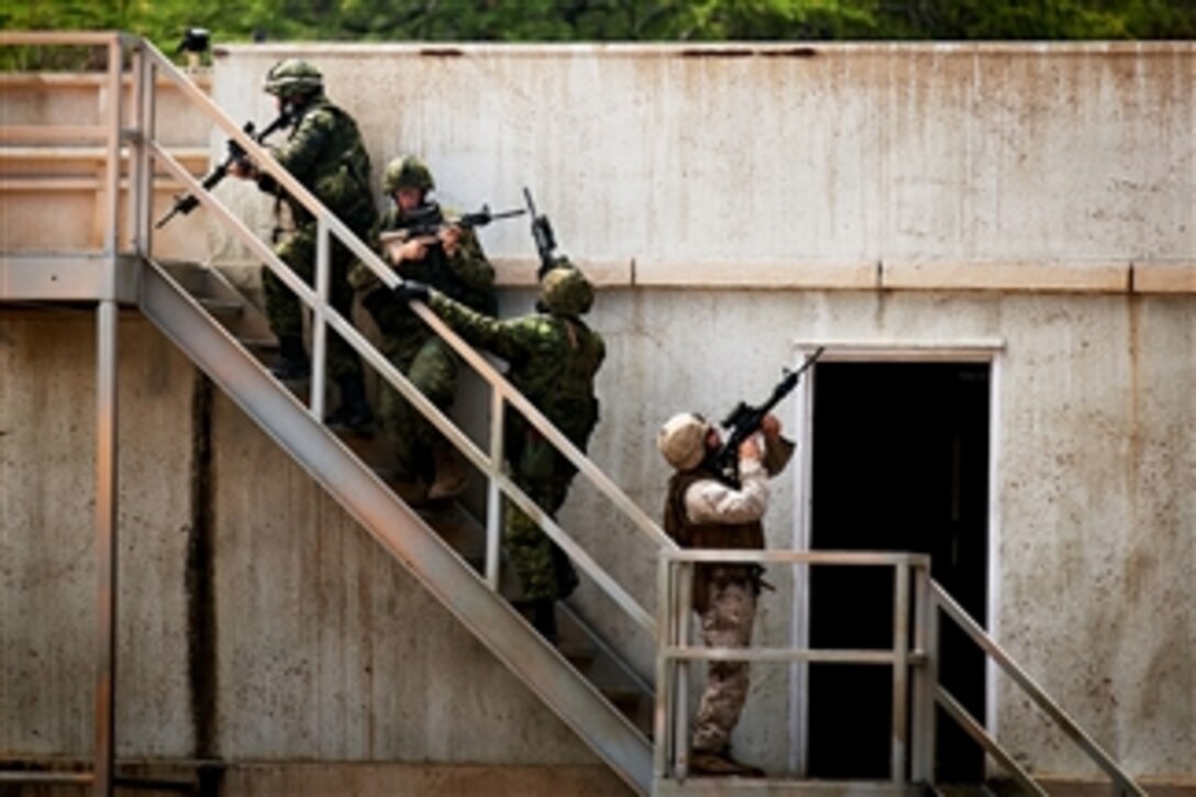 Canadian soldiers and a U.S. Marine move in as a fire team to clear a rooftop during an urban operations exercise at Marine Corps Training Area Bellows in Kaneohe Bay, Hawaii, on July 6, 2012, during the Rim of the Pacific 2012 exercise.  The exercise, more commonly know as RIMPAC, is a U.S. Pacific Command-hosted biennial multinational maritime exercise designed to foster and sustain international cooperation on the security on the world's oceans.  