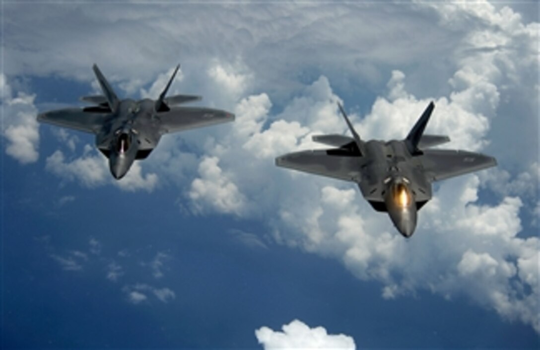 Two U.S. Air Force F-22 Raptor aircraft fly behind a KC-135 Stratotanker aircraft after receiving fuel over Joint Base Andrews, Md., on July 10, 2012.  The Raptors are attached to the 1st Fighter Wing and the Stratotanker is assigned to the 756th Air Refueling Squadron.  
