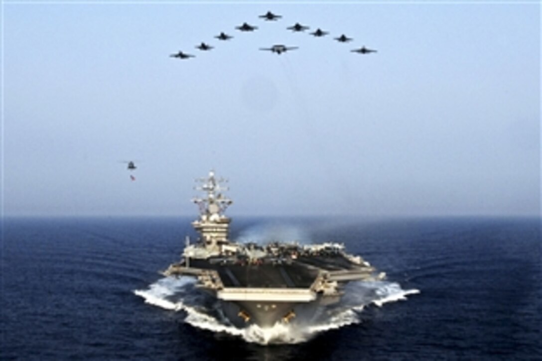 A formation of aircraft fly over the USS Dwight D. Eisenhower under way in the Mediterranean Sea, July 10, 2012. The air crews are assigned to Carrier Air Wing 7. The USS Dwight D. Eisenhower is on a scheduled deployment supporting maritime security operations and theater security cooperation efforts in the U.S. 5th and 6th Fleet areas of responsibility.
